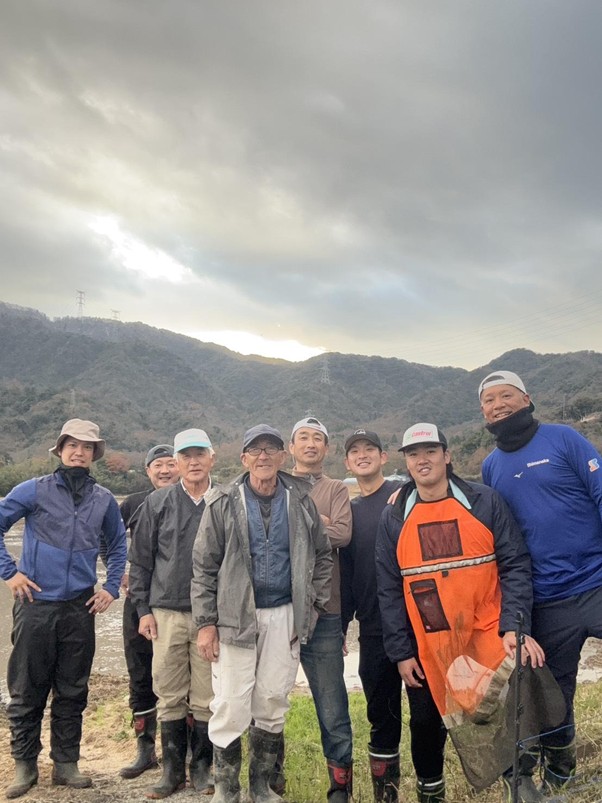 現地で農地の整備を進める社員と協力する現地の農家