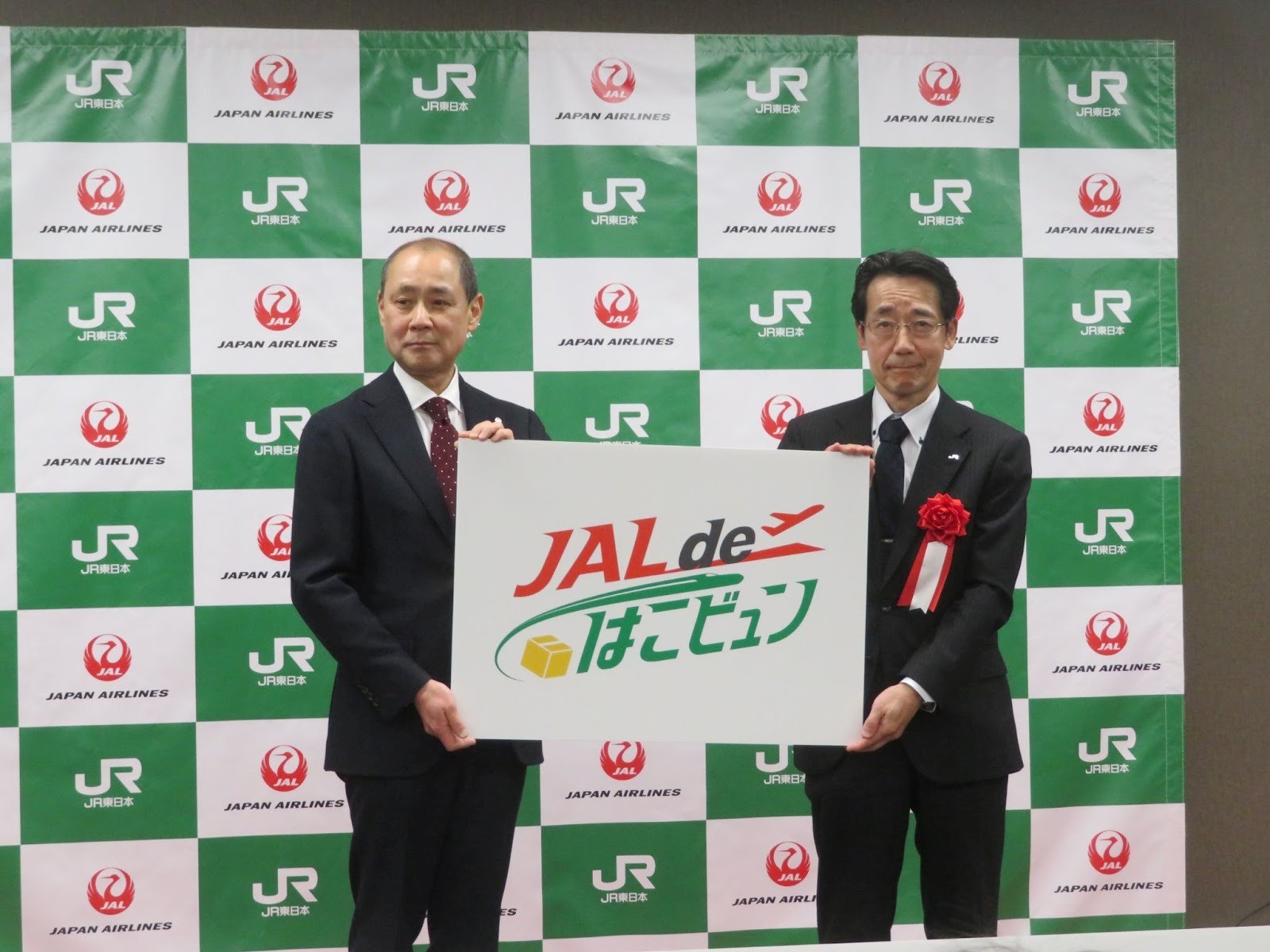 新サービスのロゴを紹介するJR東日本の髙木常務執行役員㊨とJALの木藤執行役員