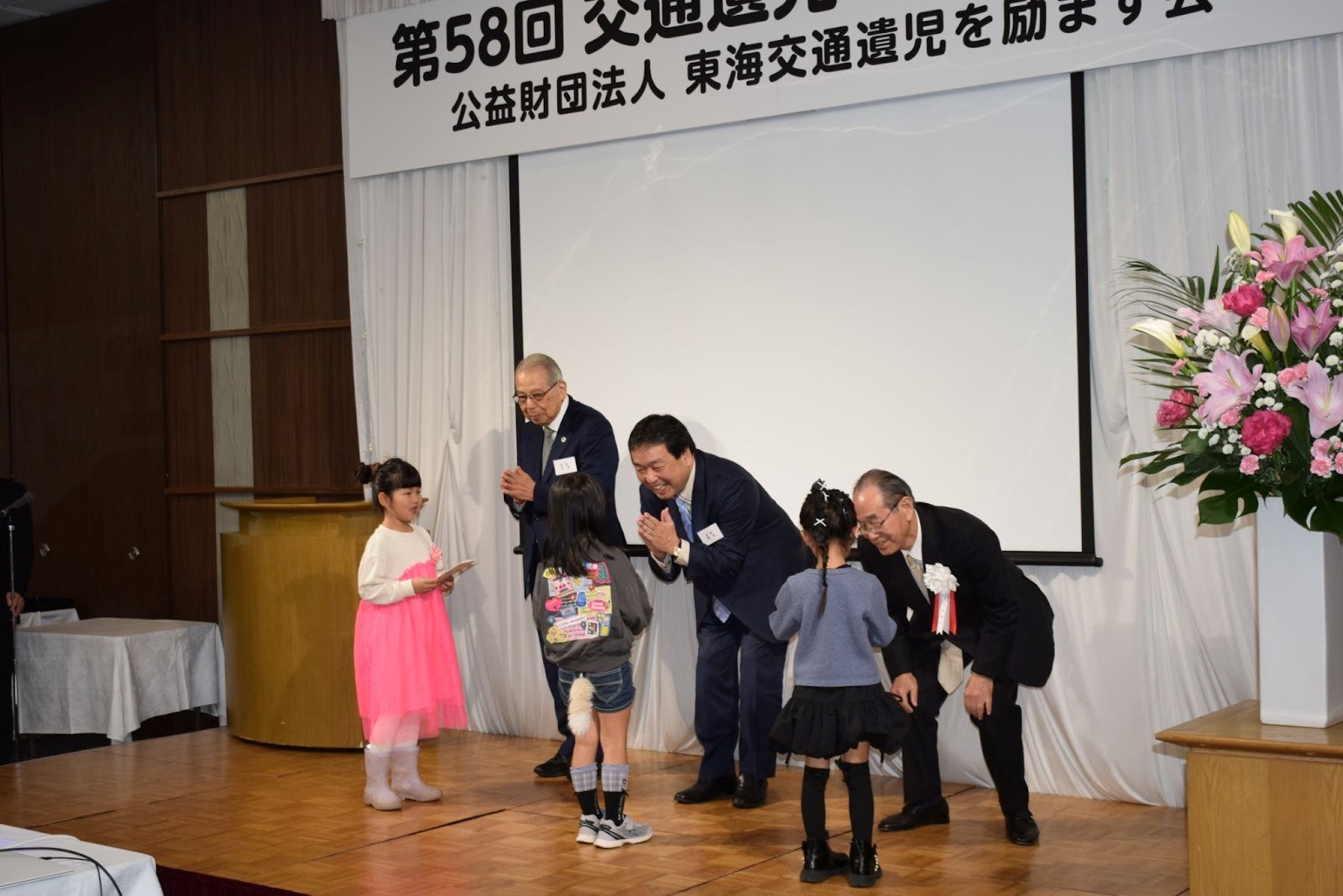 4月から小学校に入学する児童3人に入学祝い金と記念品を贈る吉野会長（右端）ら