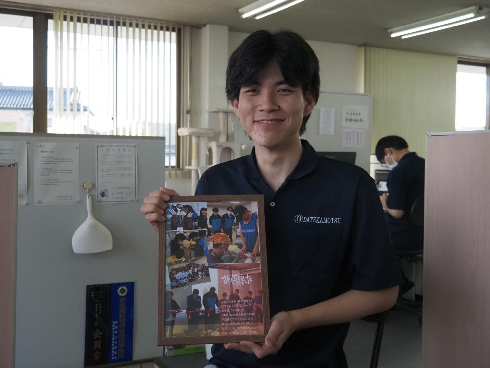 「ゆめのまちココマム」参加者からの感謝状を手にほほ笑む酒井総務・経理部主任