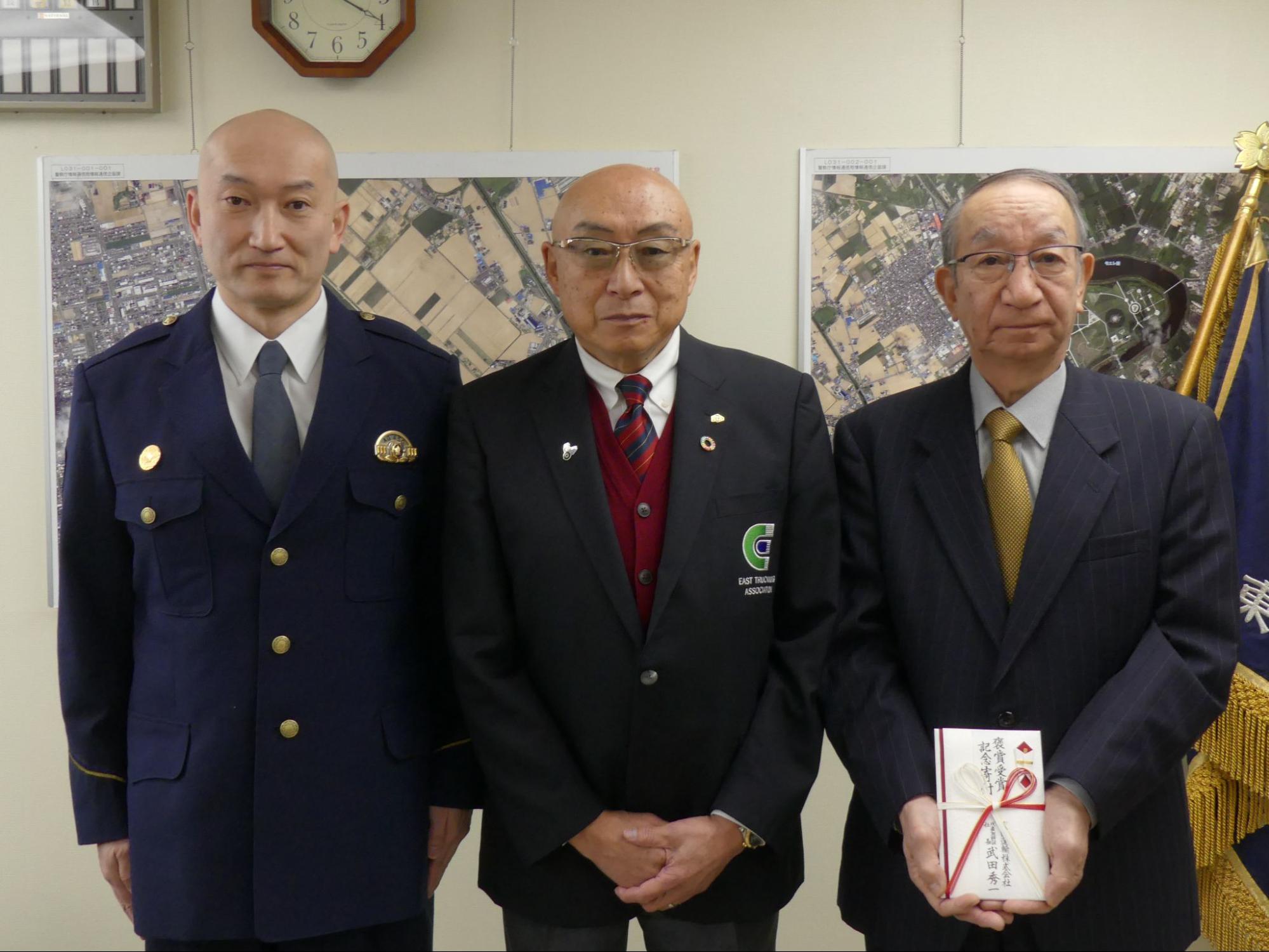 記念写真に納まる武田社長（中央）ら