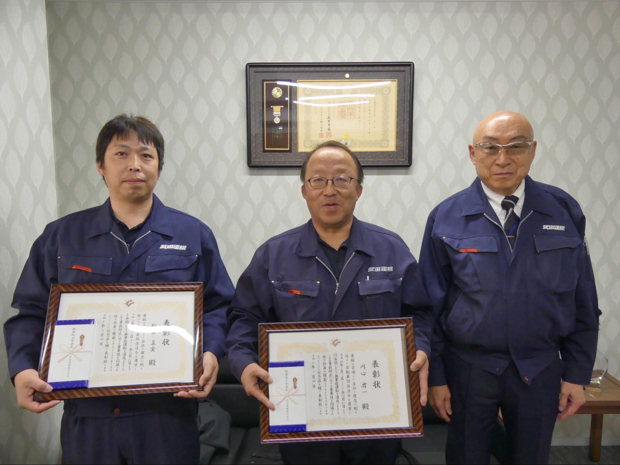 （右から）武田社長と、表彰状を持つドライバーの川口氏、松栄氏