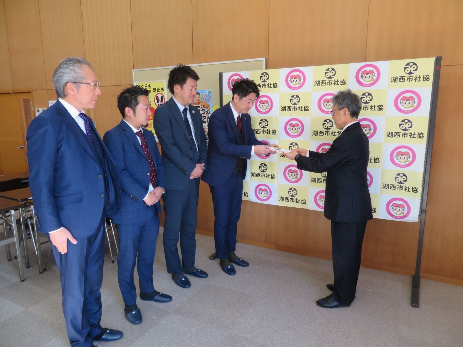 湖西市社協の担当者（右端）に目録を渡す加藤青年部会長と支部役員ら