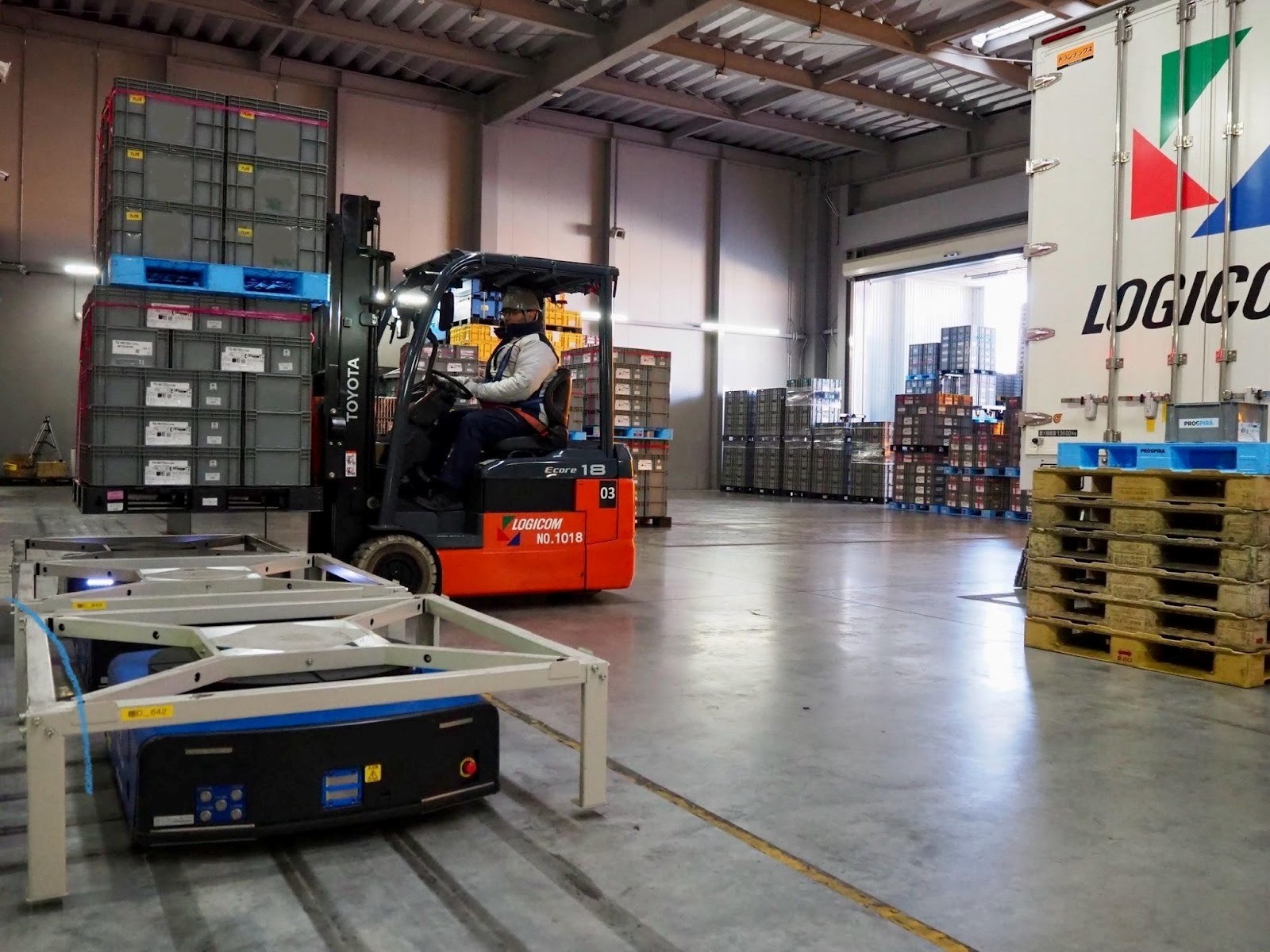 匠のAGVにフォークリフトで部品を積むトラックドライバー