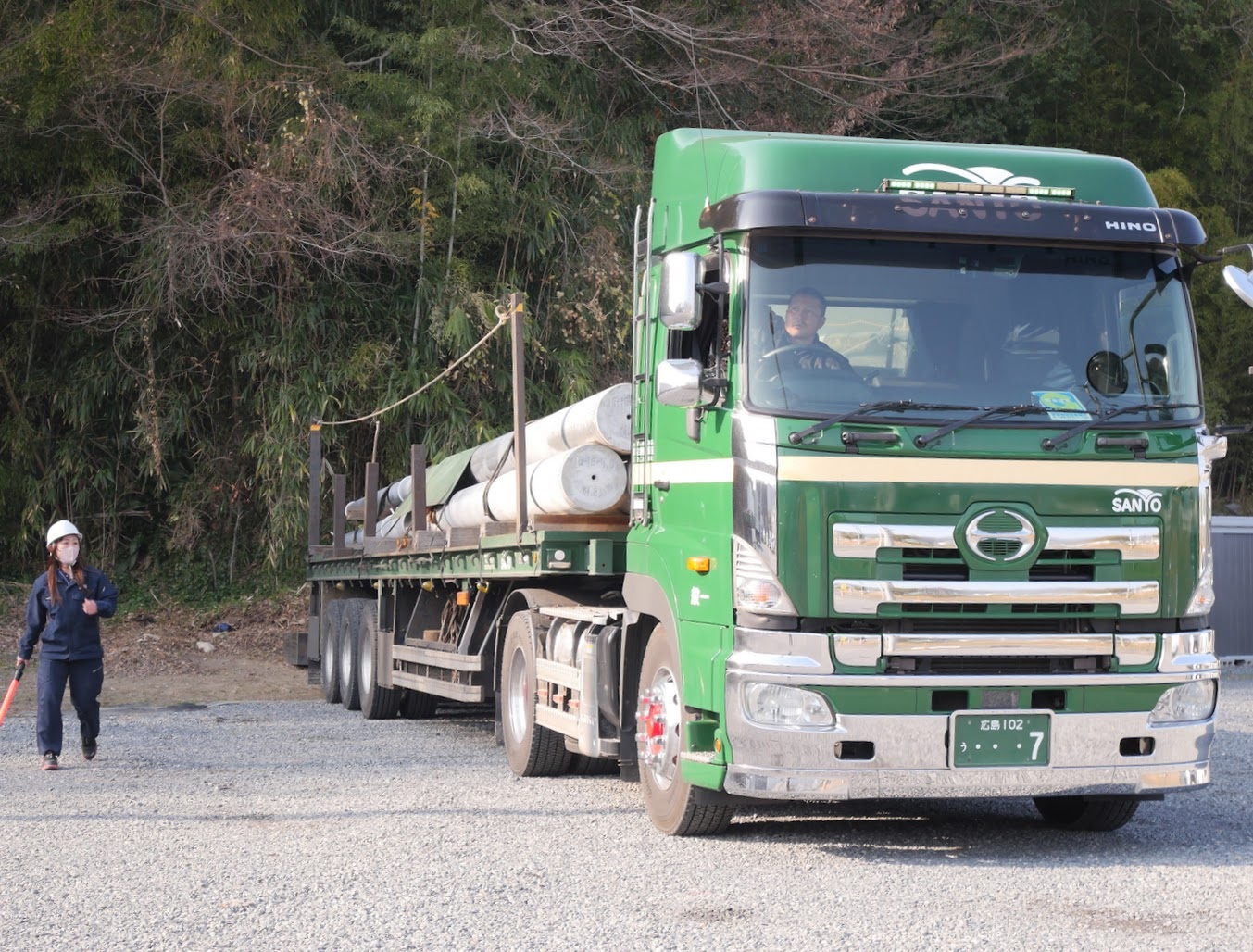 電柱を運ぶトレーラを誘導
