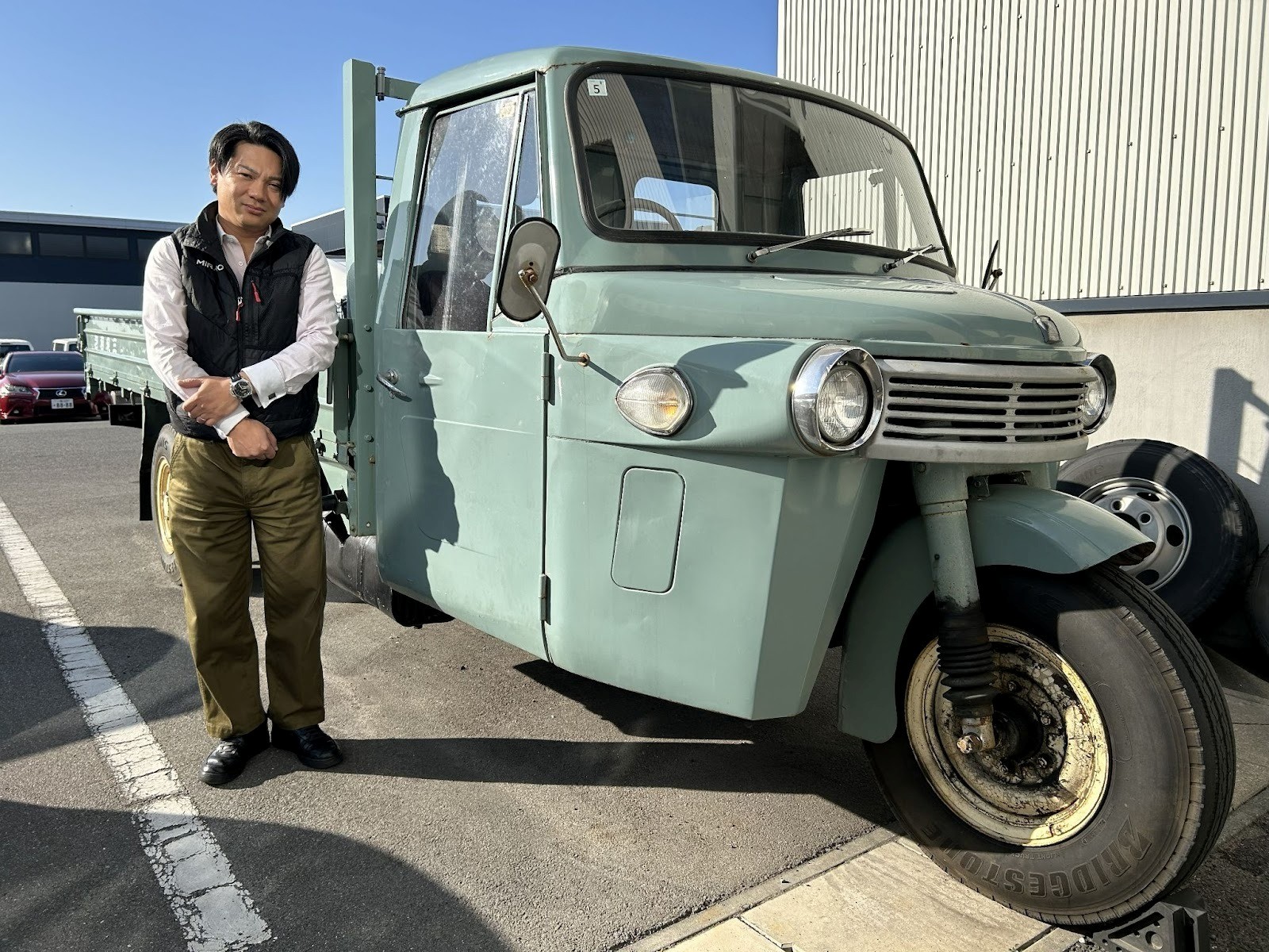 オート三輪トラックの横に立つ橋本社長