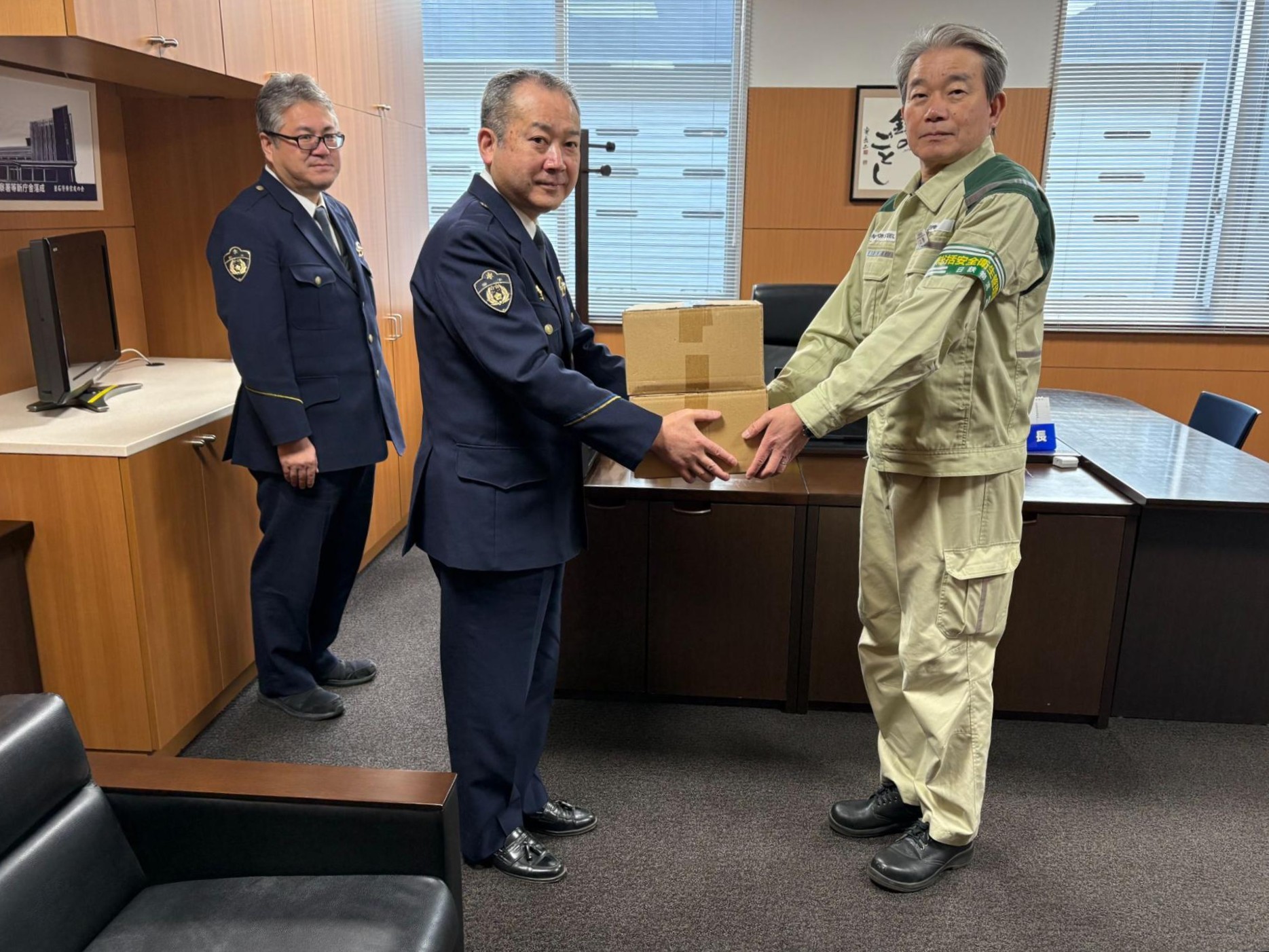 釜石署の松本署長㊧にクリップライトを手渡す上野支部長