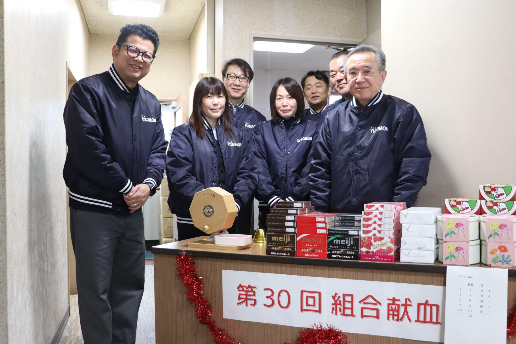 そろいのジャンパー姿で受付に立つ職員や組合員の従業員