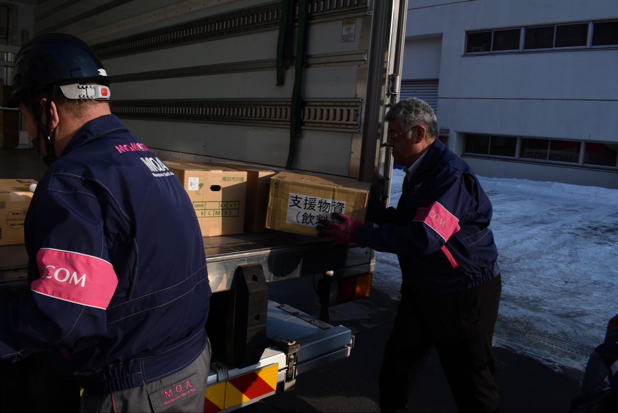 トラックに救援物資を積み込むAZCOMネットの参加者（14日）