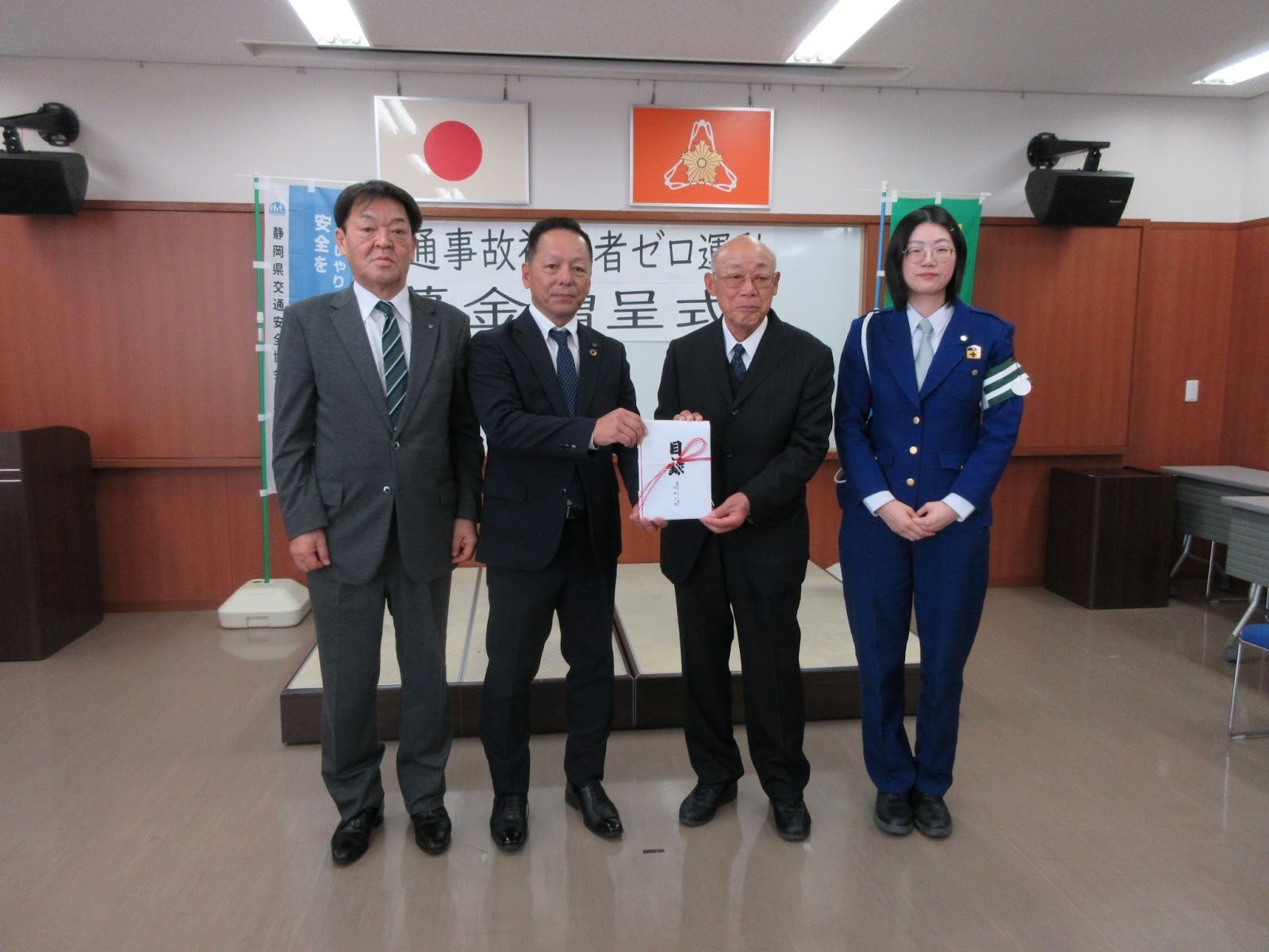 県交安協袋井地区支部の袴田支部長（右から2人目）に目録を手渡す髙瀨支部長（左隣）