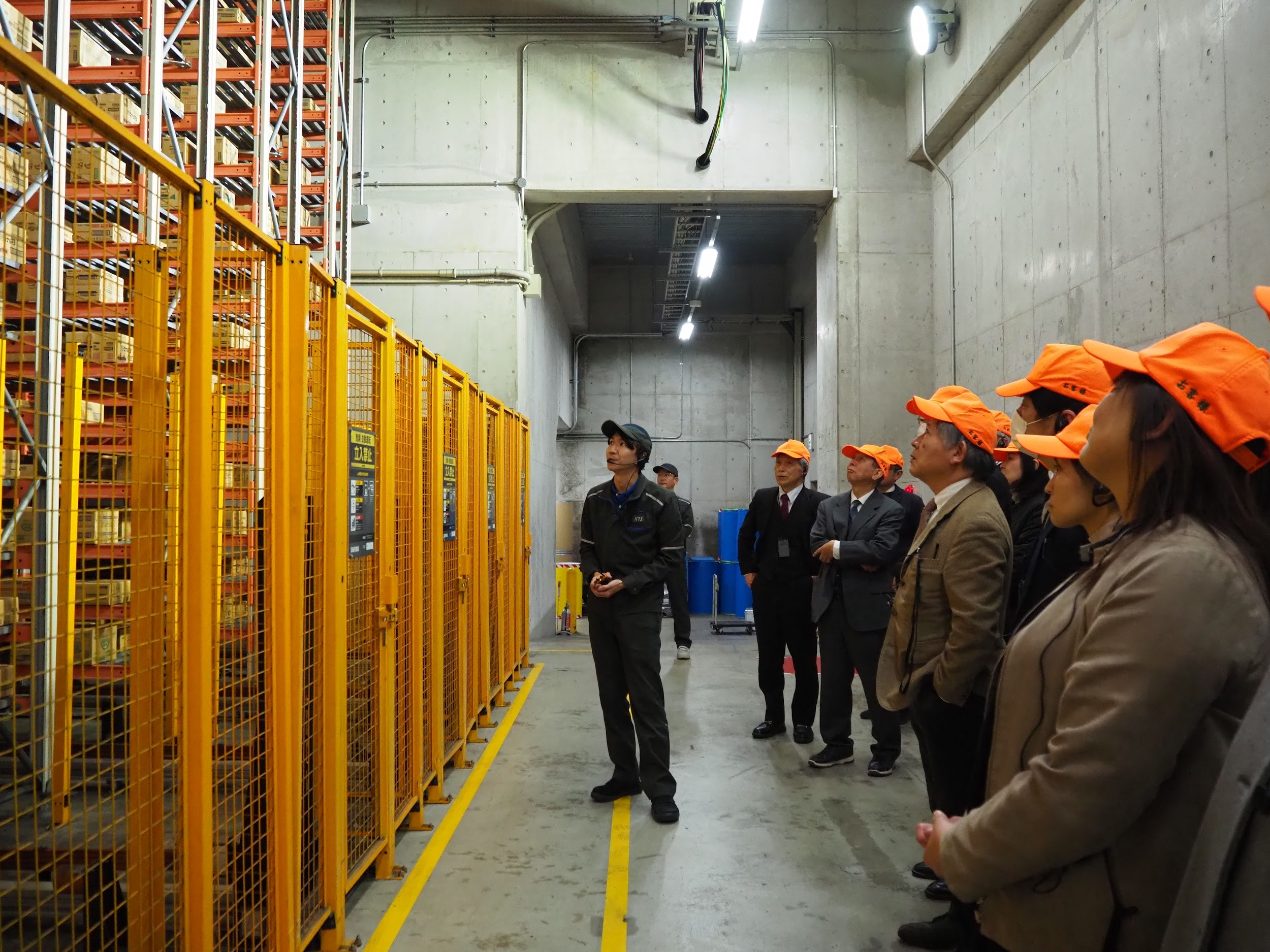 KRS職員の案内で倉庫内を見学する進路指導担当の高校教諭ら