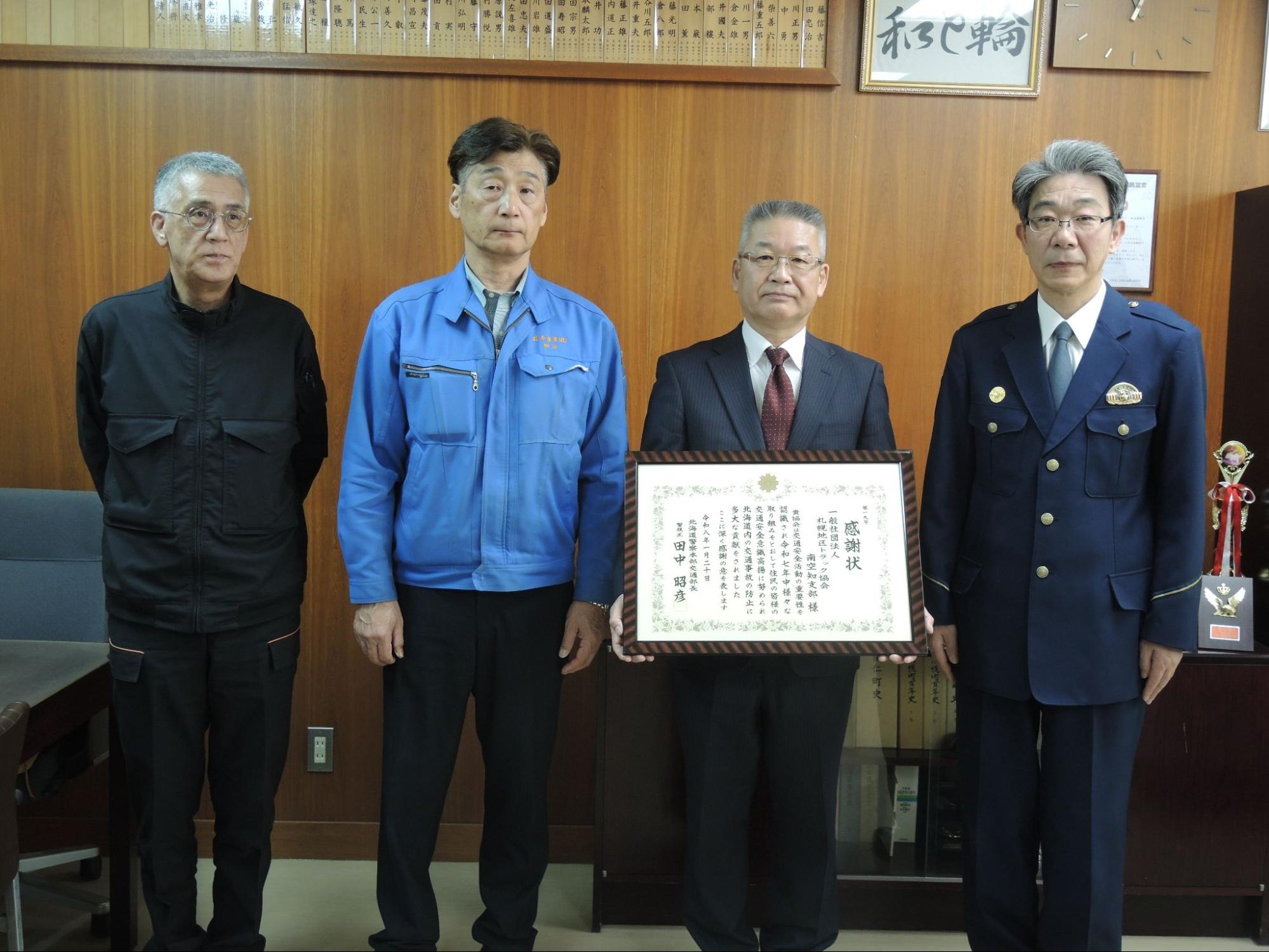 記念撮影に応じる工藤支部長（右から2人目）と栗山署の木下署長（右隣）ら