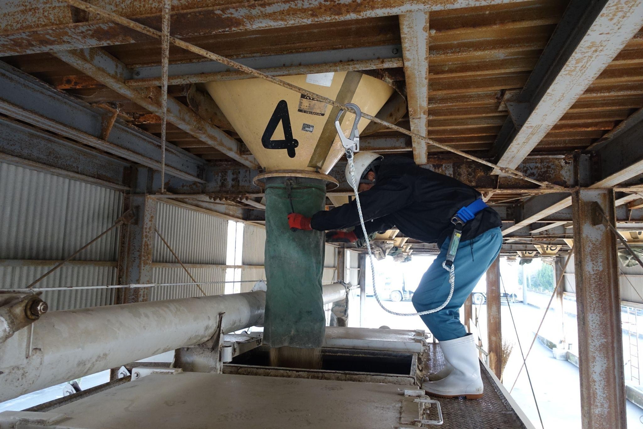 天井に安全帯のフックをかけて作業するドライバー