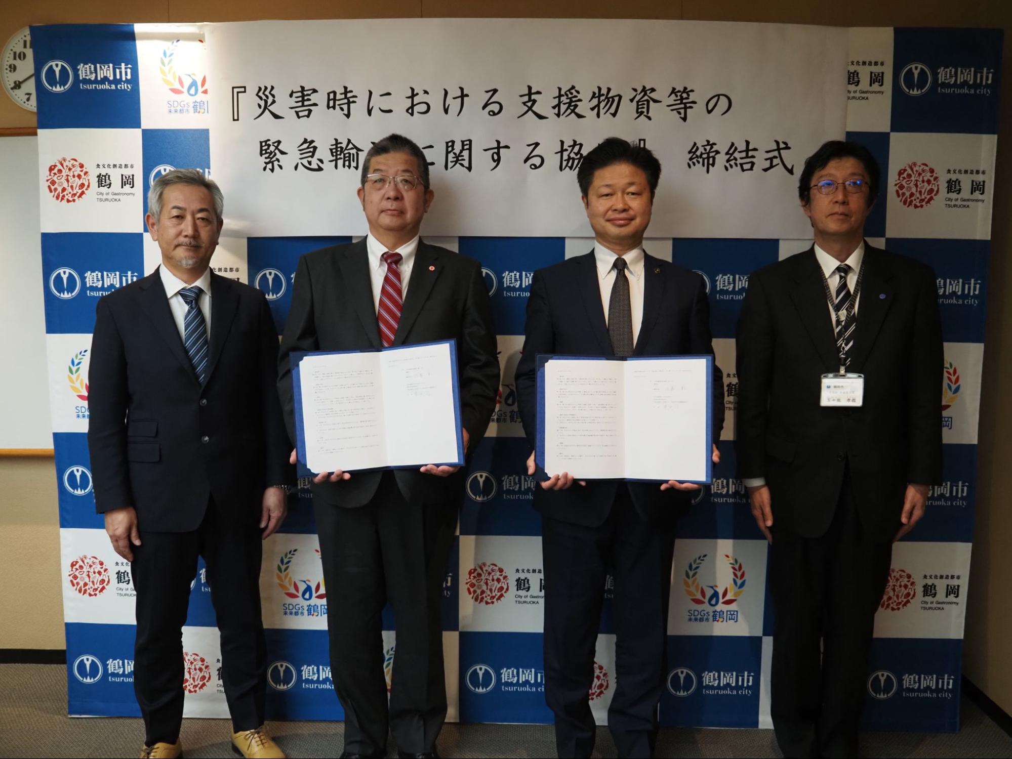 協定書を持つ菅原会長（左から2人目）と佐藤聡市長（右隣）ら
