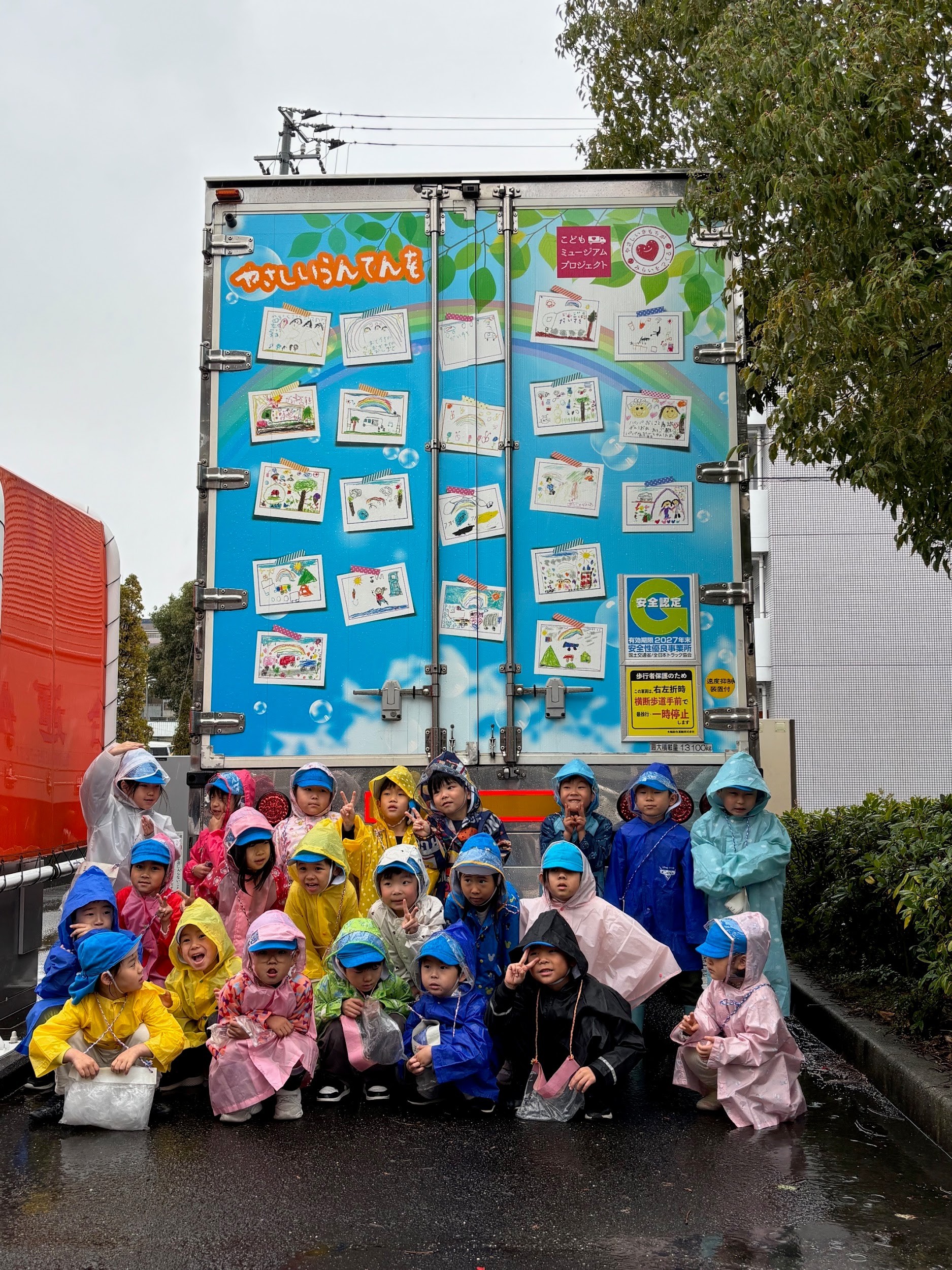 ラッピングトラックの前で園児ら