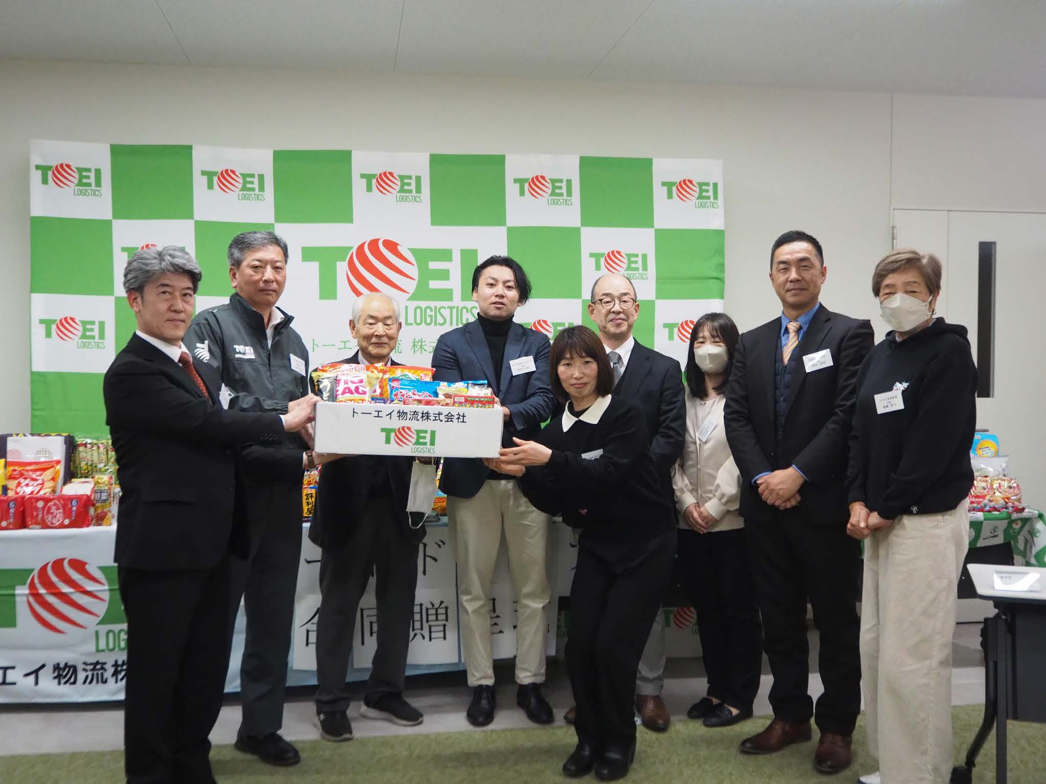 子ども食堂へ食料品を手渡すトーエイ物流の伊藤専務（左から2人目）ら