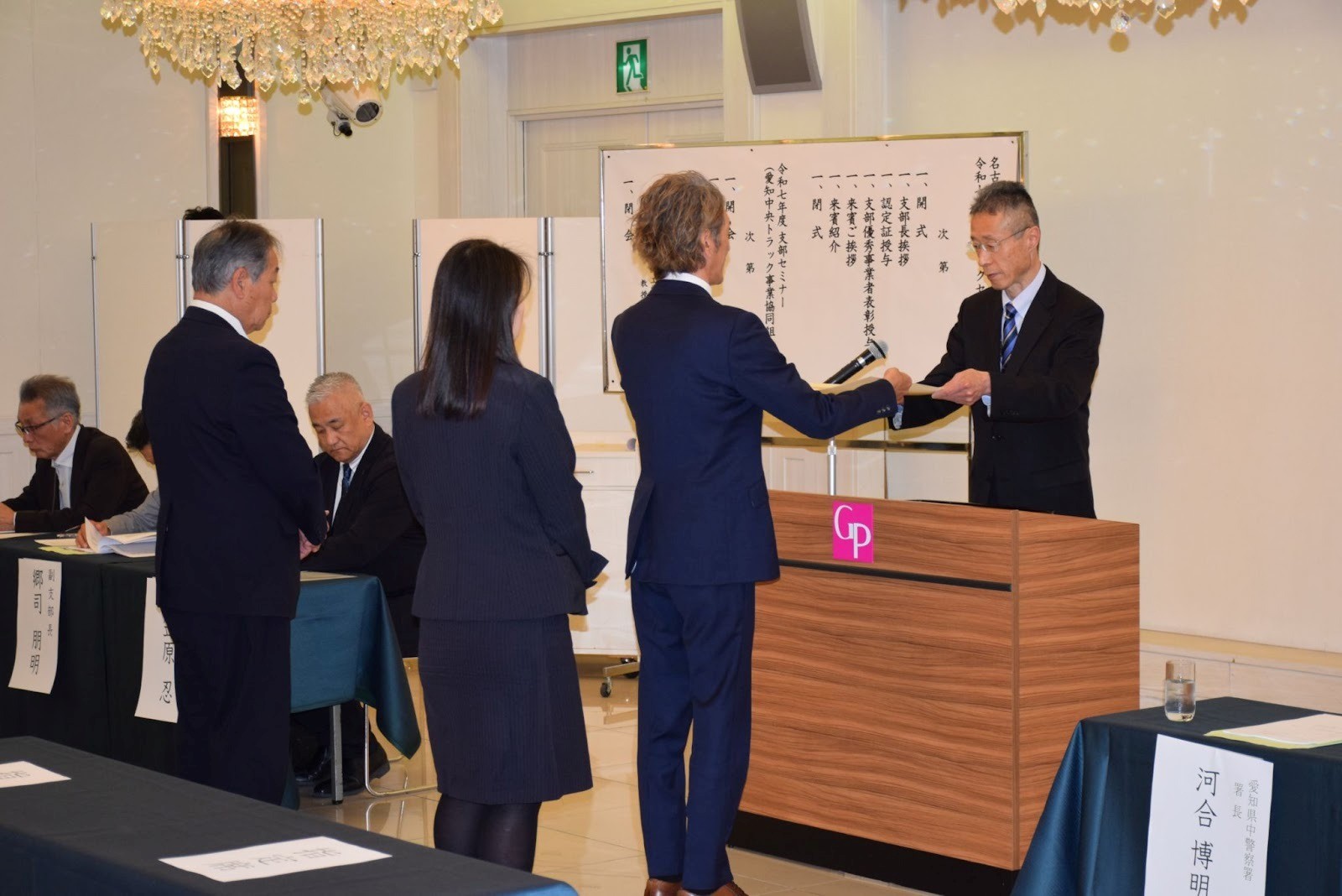 中警察署の河合署長㊨から賞状を受け取る達成事業者の代表者