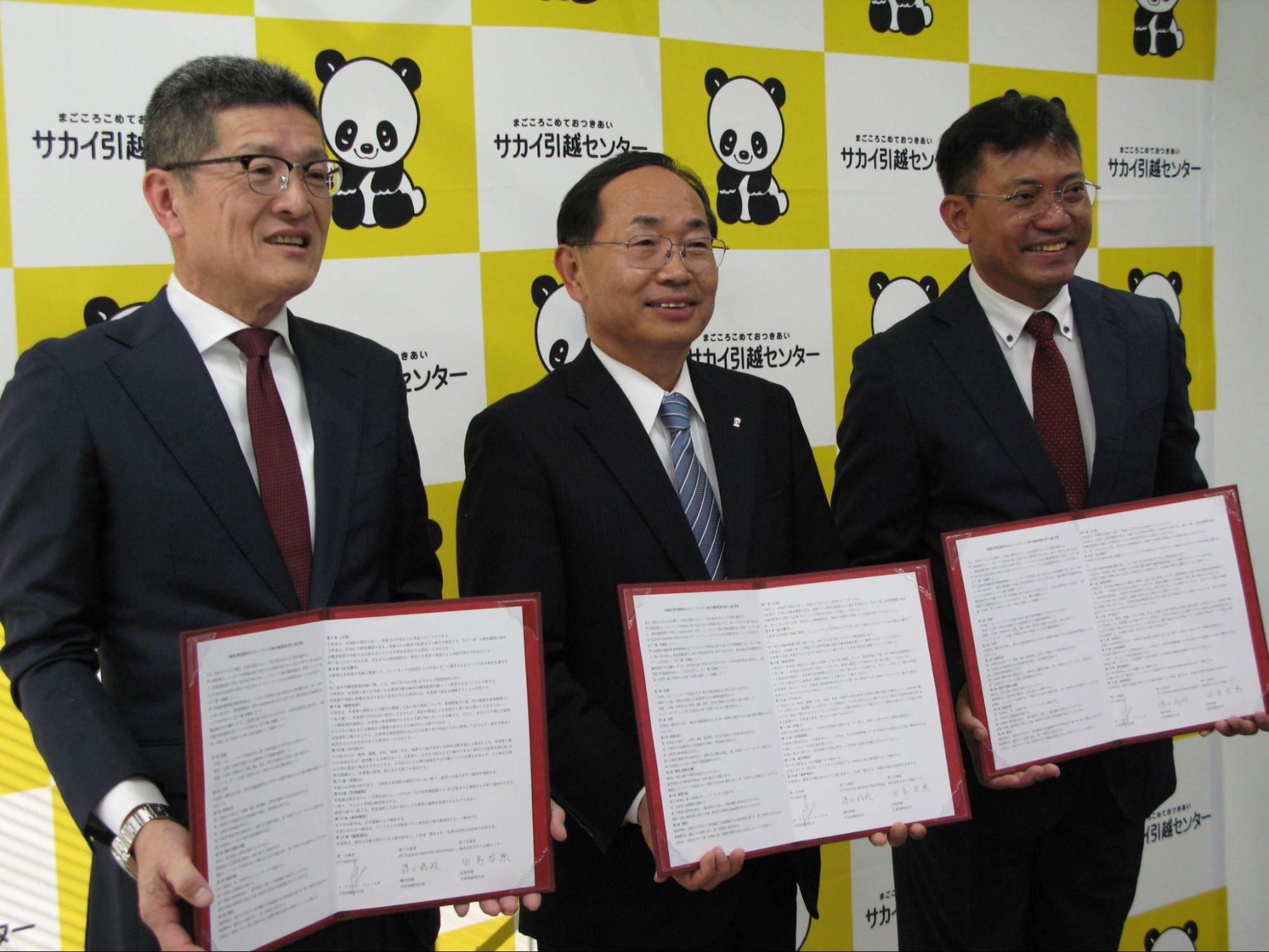 覚書を手に田島社長（中央）、ミノリのワヒュー代表（右隣）、DMIの藤田社長