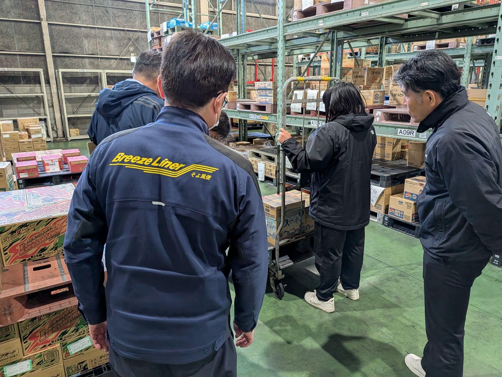 野坂管理本部長（手前）とともに、倉庫作業を体験する自衛隊員