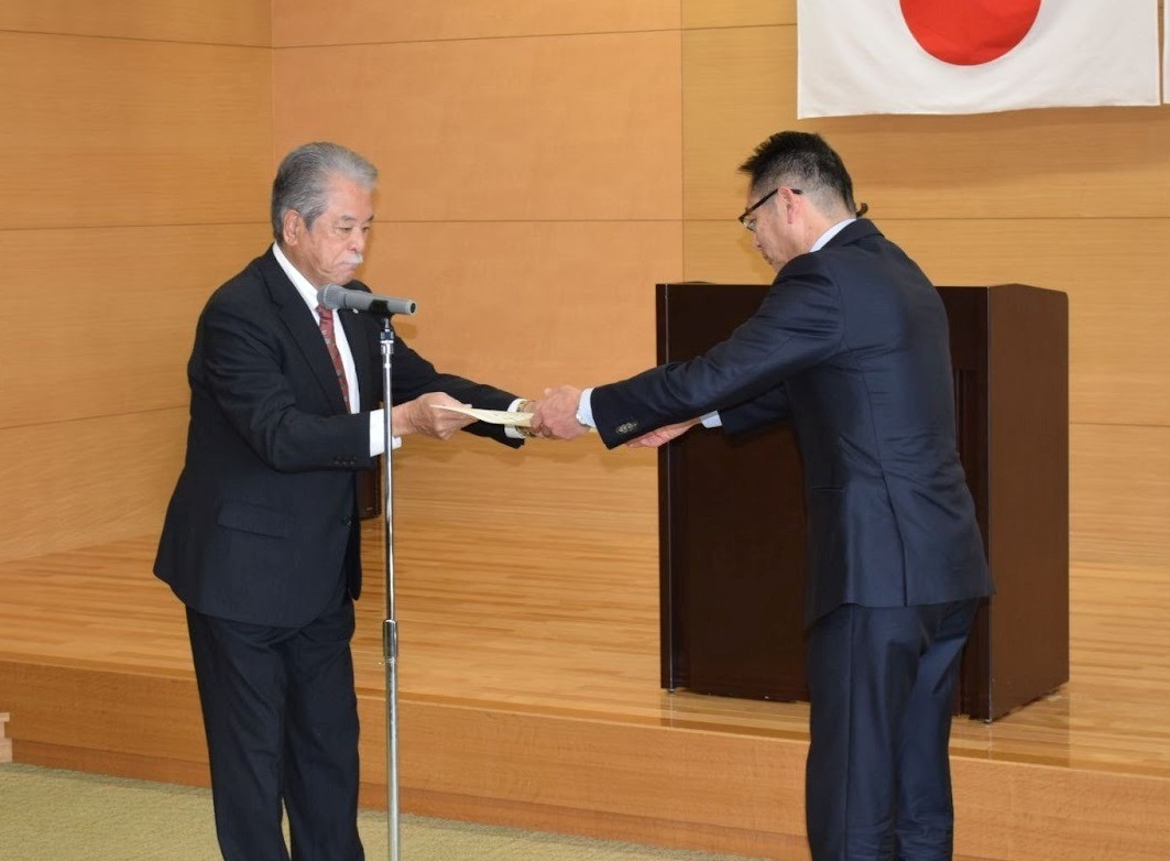 功労役員に表彰状を渡す佐野会長㊧