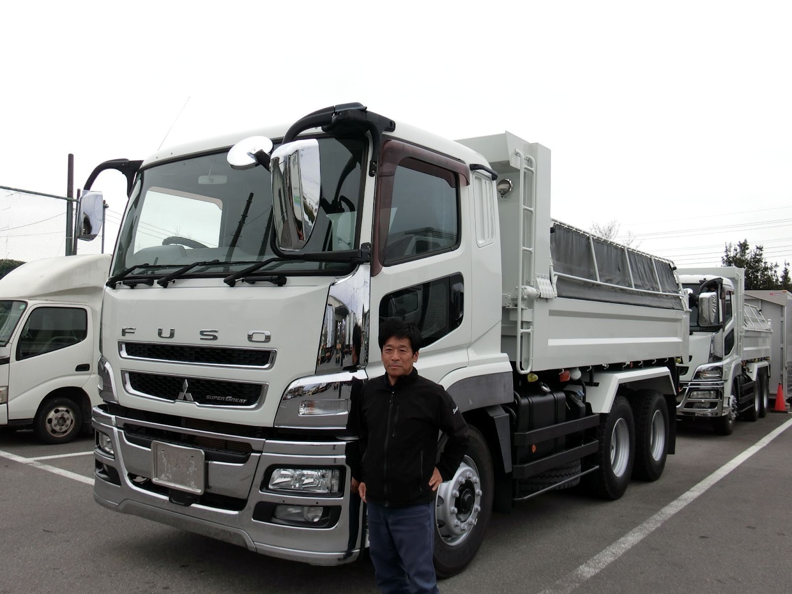 センヨシ納車されたダンプ車と業務課の関根課長ロジ ダンプでセメント輸送