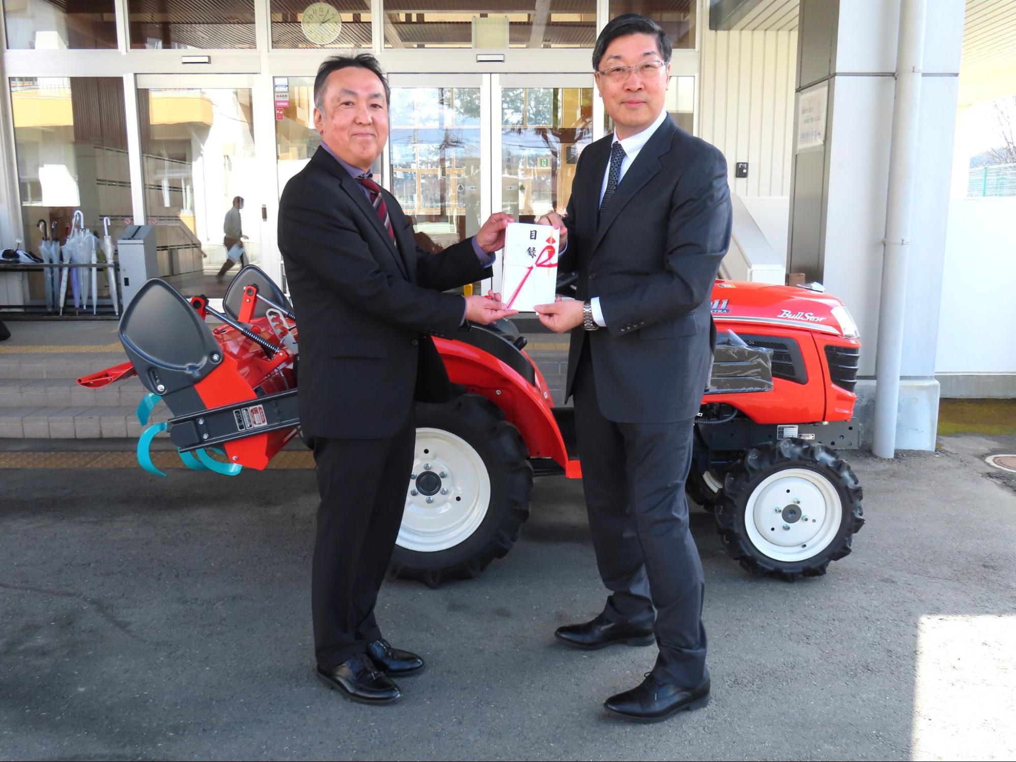 目録を持つ一関清明支援学校の外舘校長㊧と菅原社長