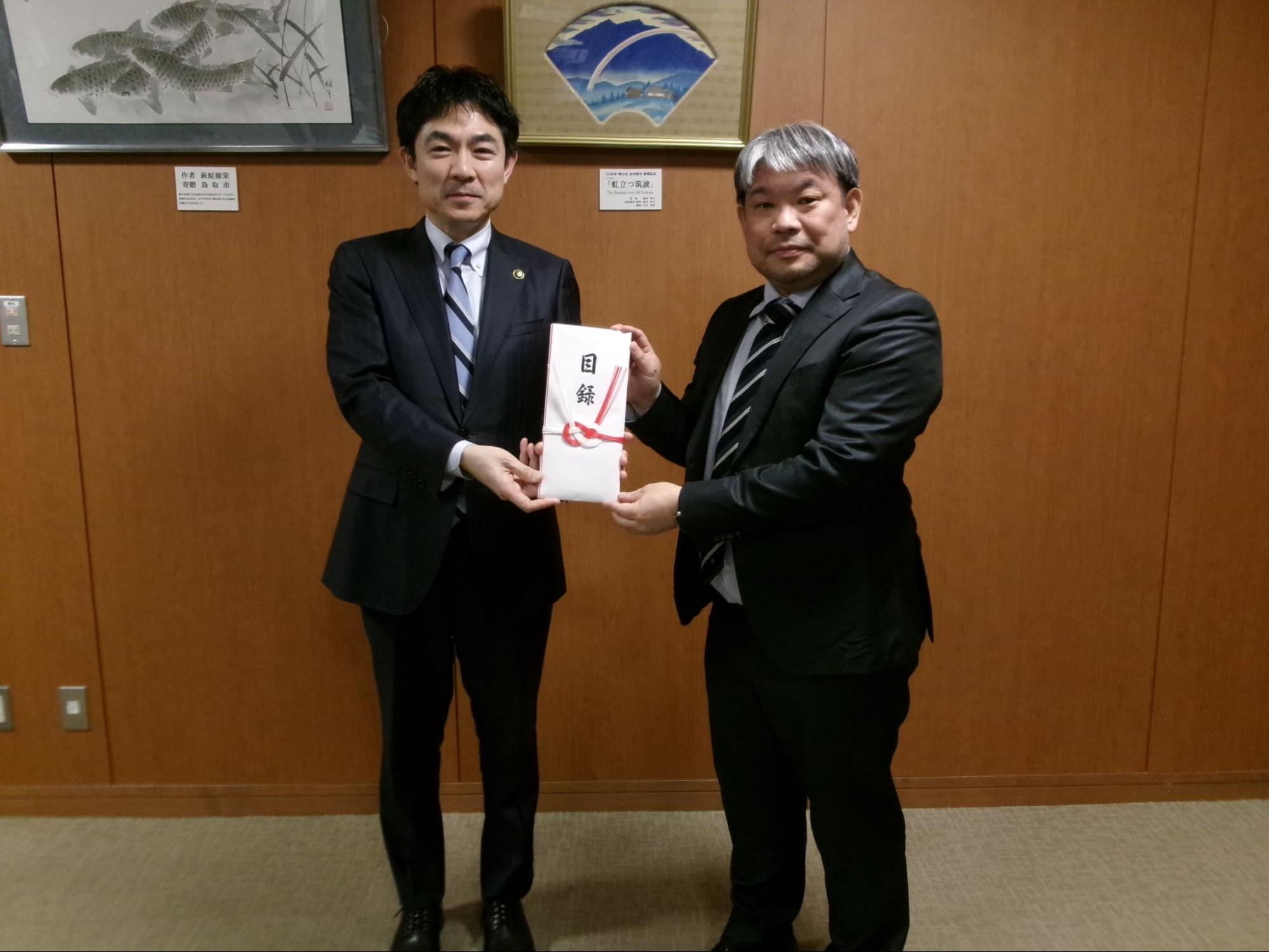 感謝状と目録を手に椎根市長㊧と石田会長