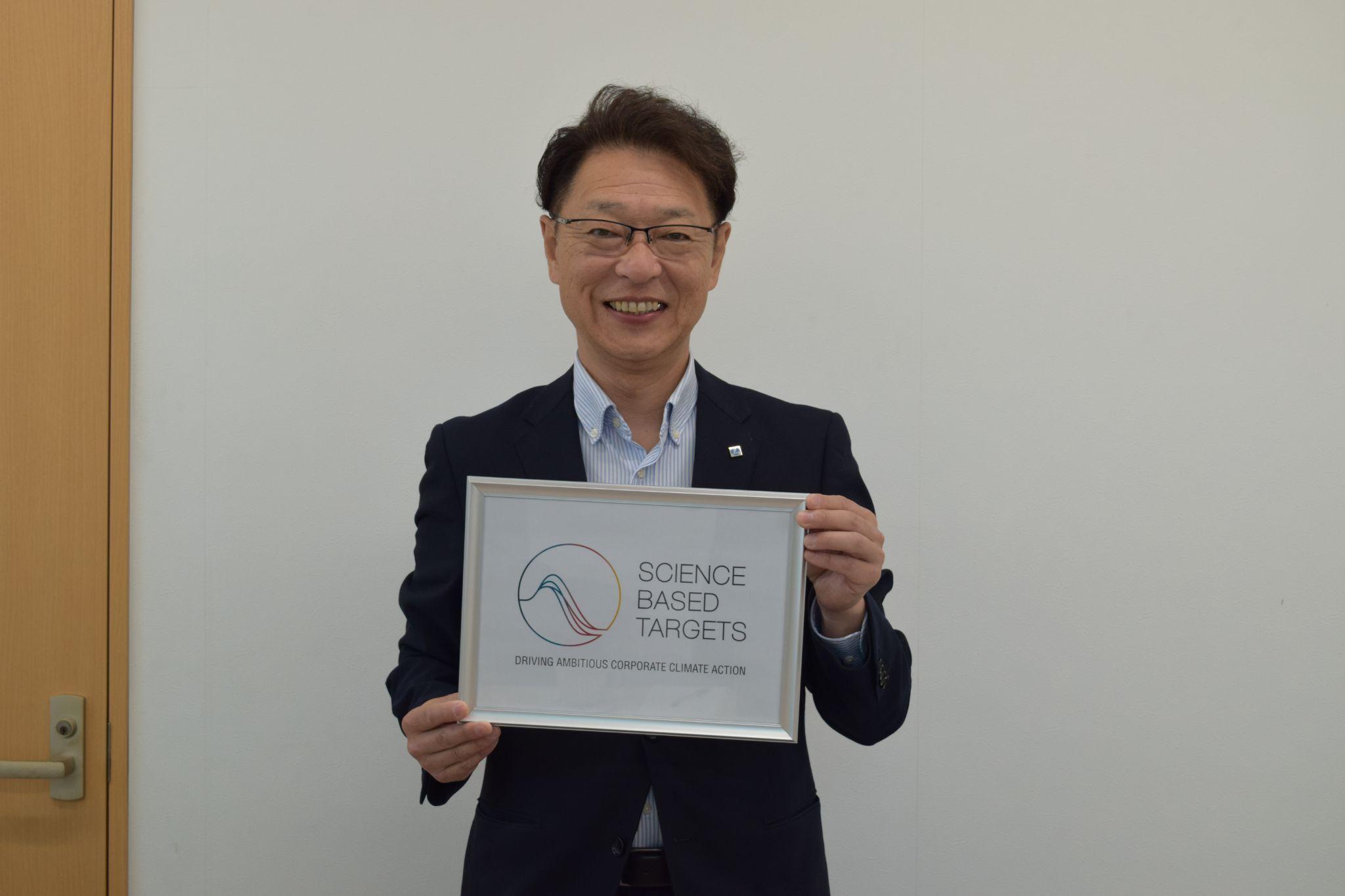 認定証を持つ新村社長<br>