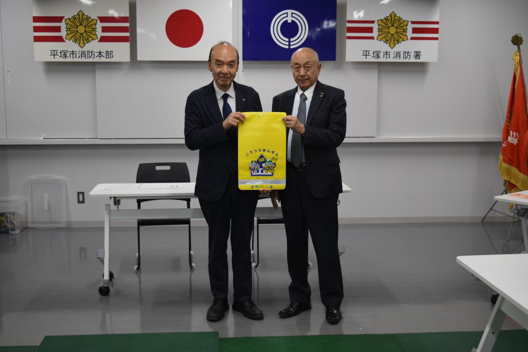 ランドセルカバーを持つ伊藤広報委員長㊨と吉野教育長<br>