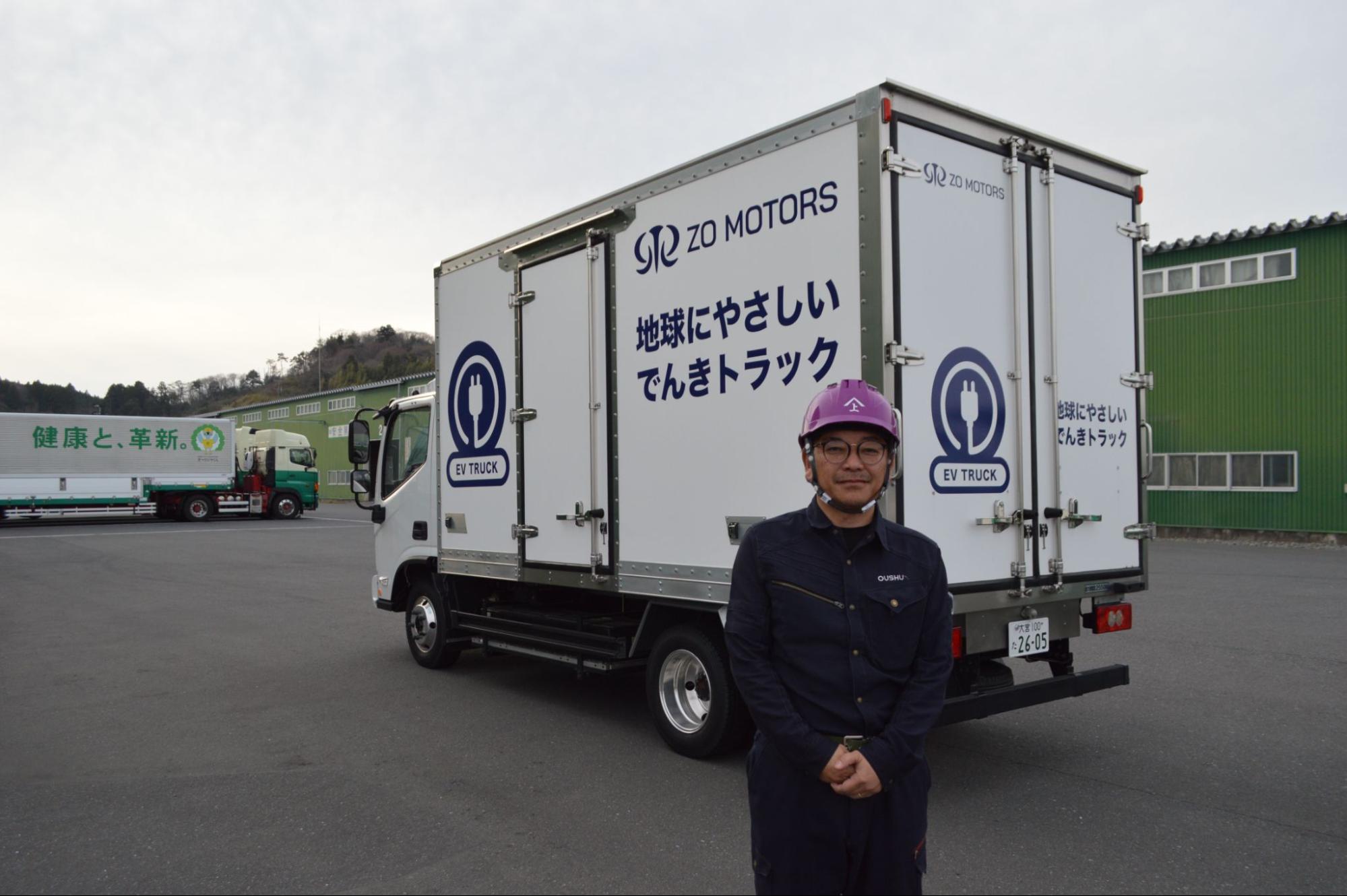 電気トラックの前で菅井部長