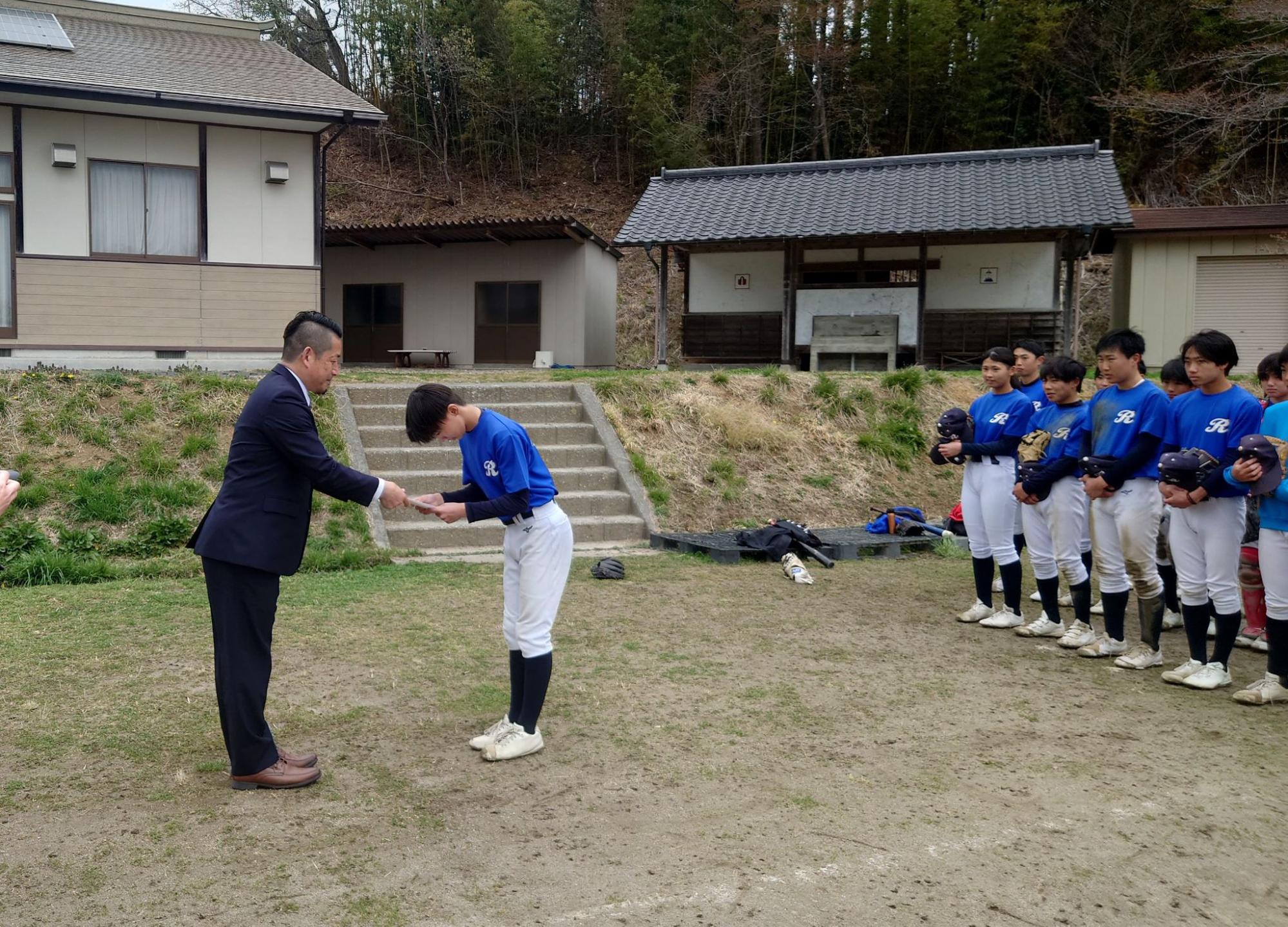本吉ロビンの日下主将に寄付金を手渡す小野寺部長