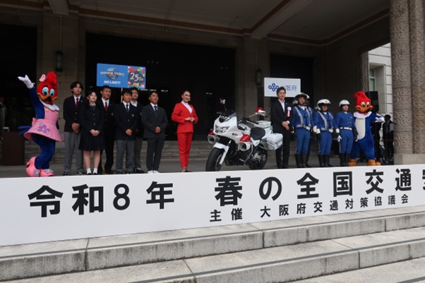 白バイと共に記念写真に納まる吉村知事と高校生ら