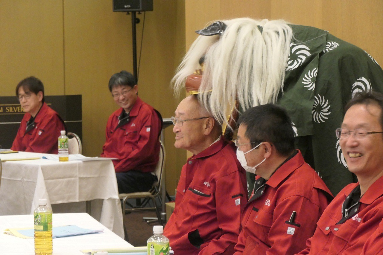 川﨑社長（左から2人目）が獅子舞に頭をかみつかれ、会場が盛り上がる