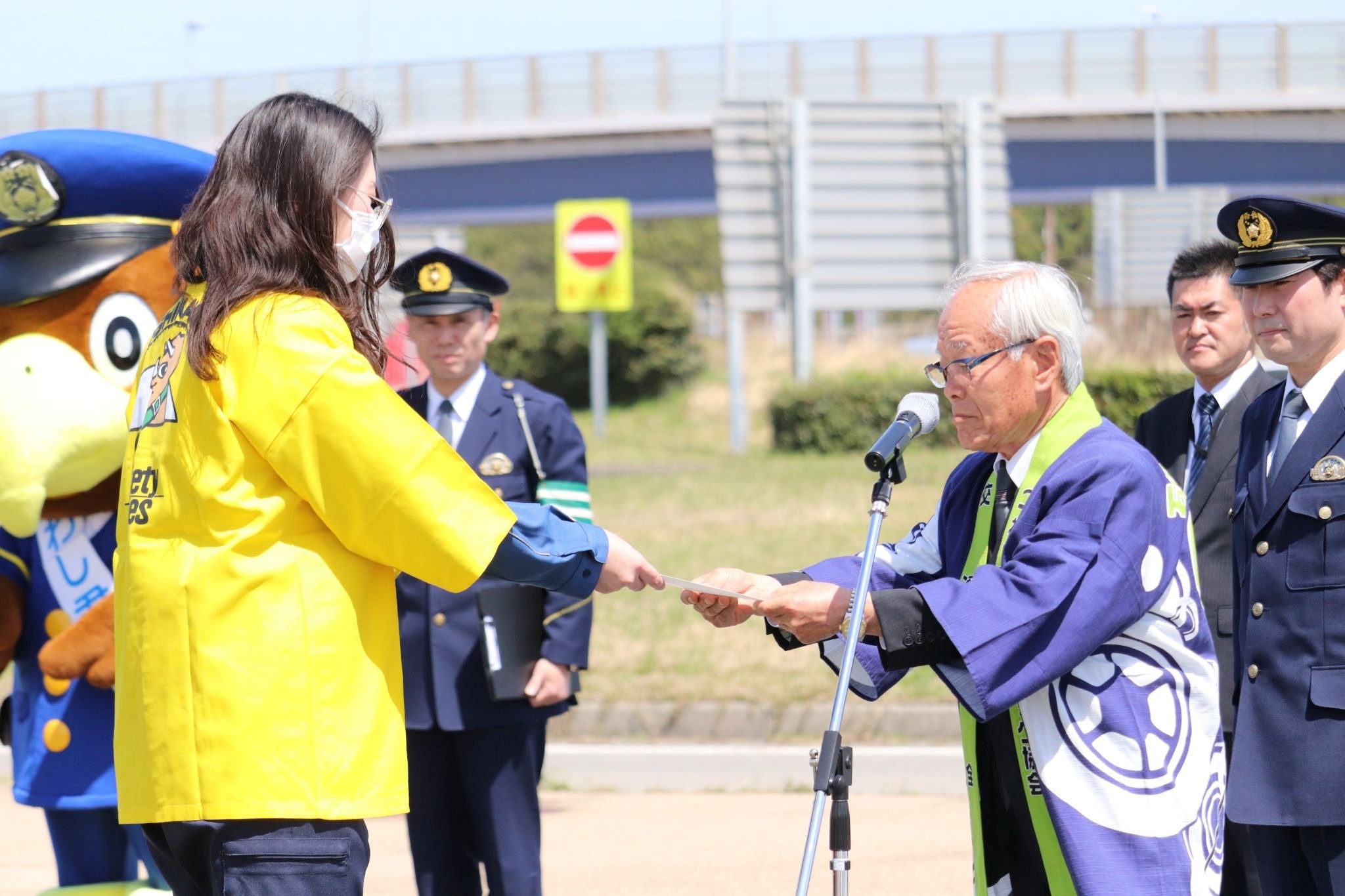 ハイウェイ・セーフティレディに委嘱状を手渡す山田会長（手前右）