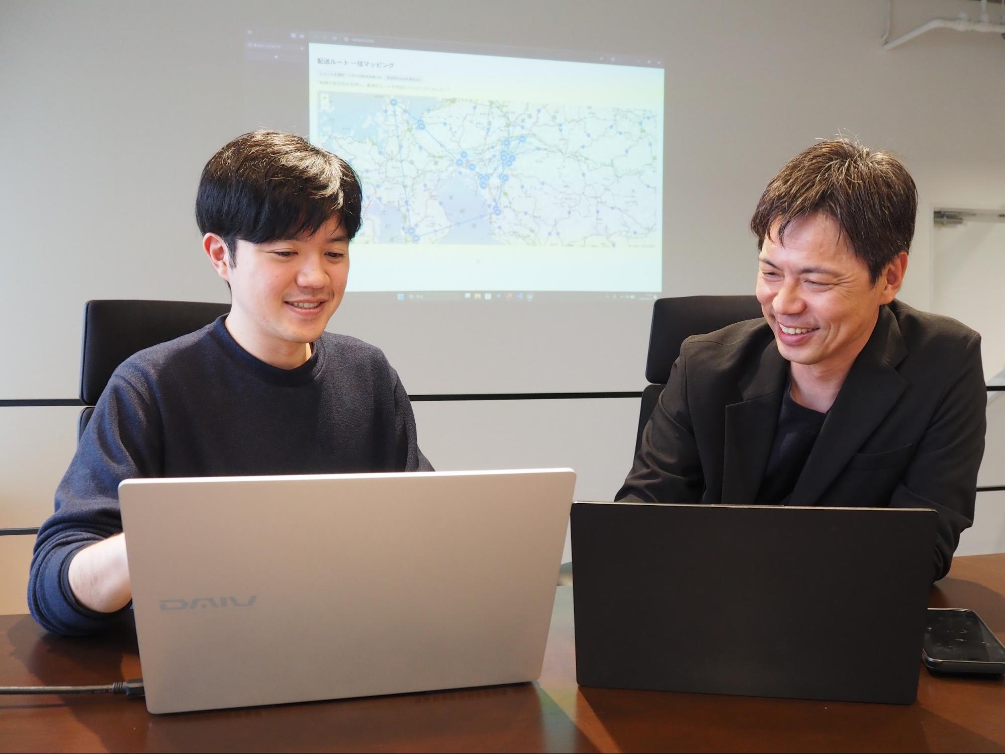 平田さん㊧からAI研究の報告を受ける柳営業本部長