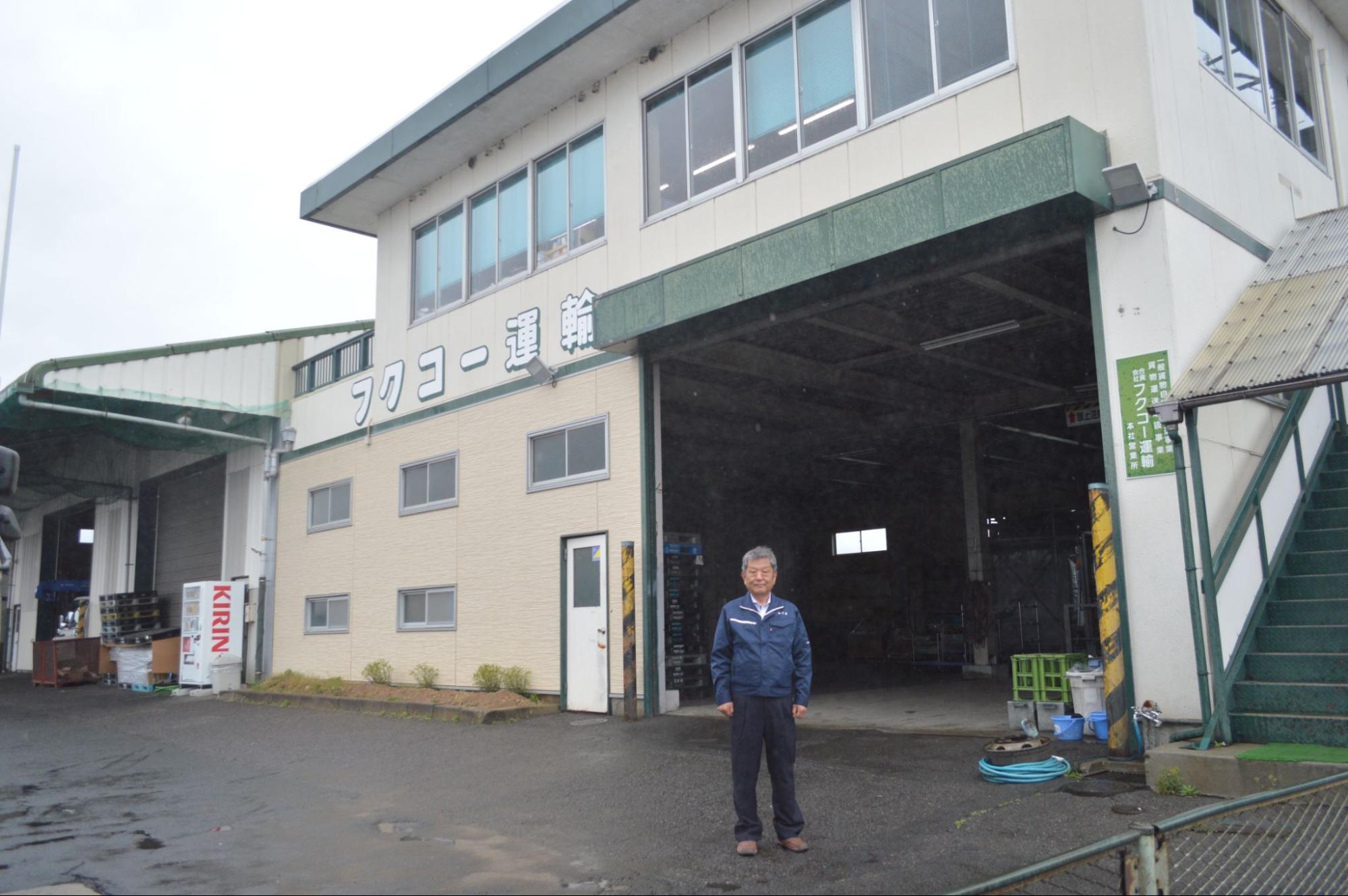 フクコー運輸の本社前に立つ渡部常務