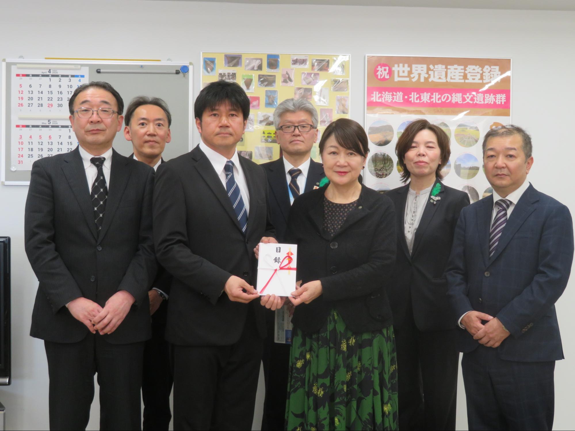 目録を持つ棟方委員長（前列左から2人目）と県の風張教育長（右隣）