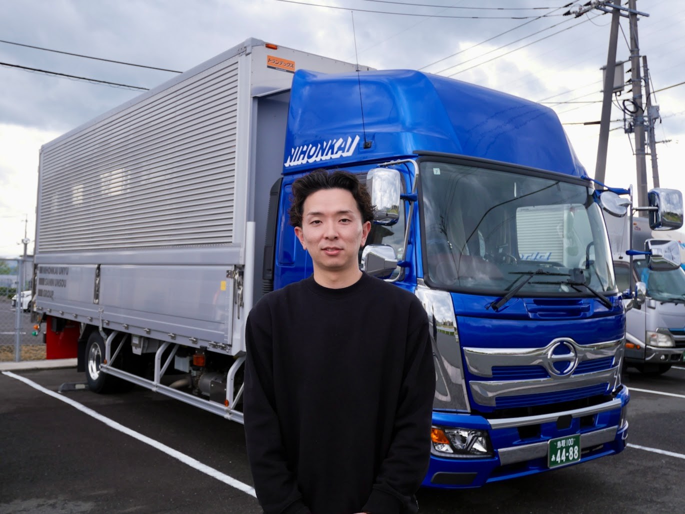 自社トラックの前で楮原社長