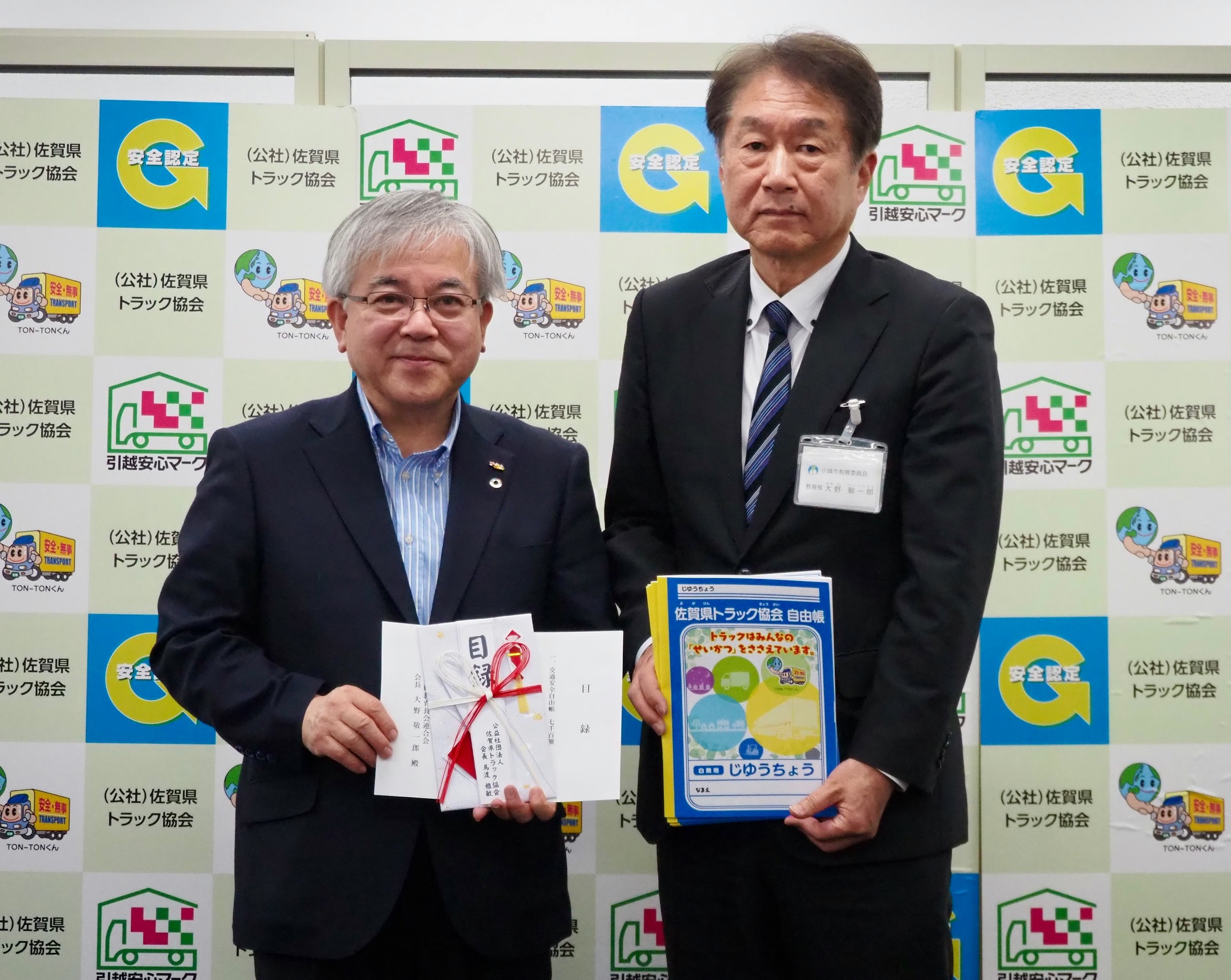 県教連の大野会長㊨に自由帳を手渡す馬渡会長