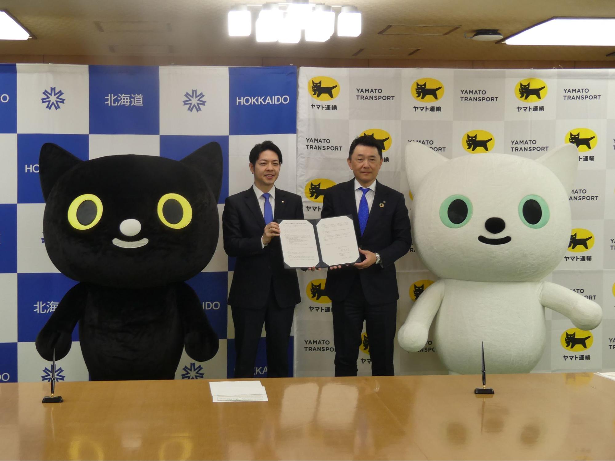 協定書を手に阿波社長㊨と鈴木知事