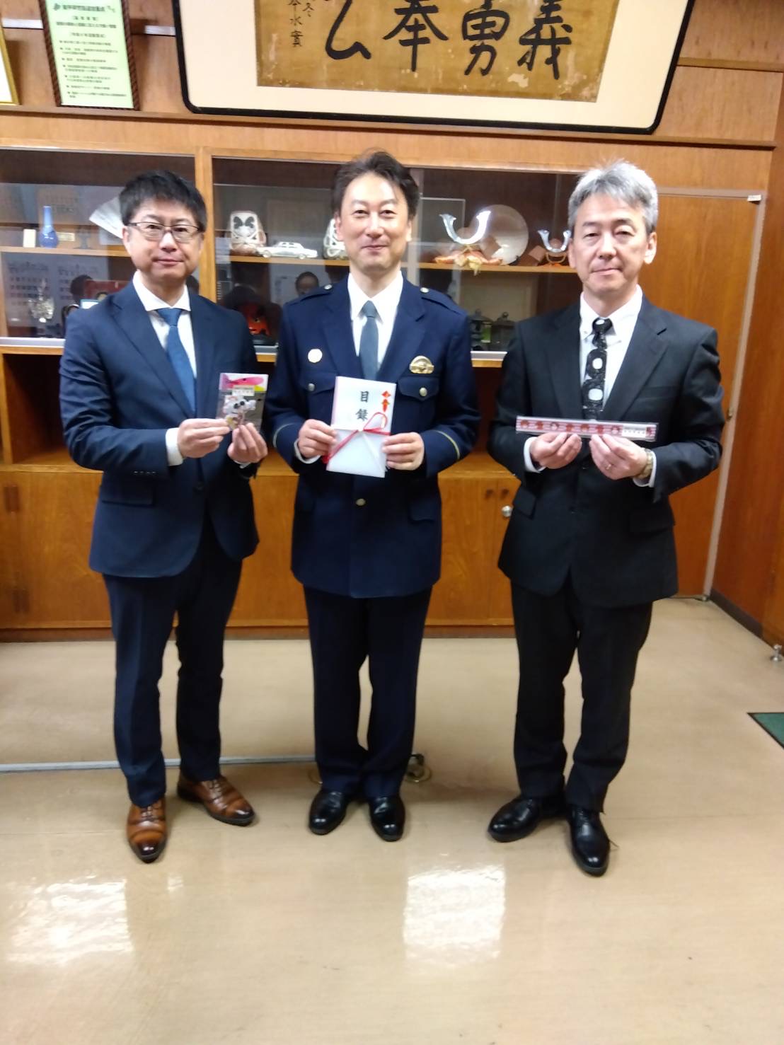 反射材や目録を持つ海鋒支部長（左端）と高橋副支部長（右端）、奥州署の向川原署長