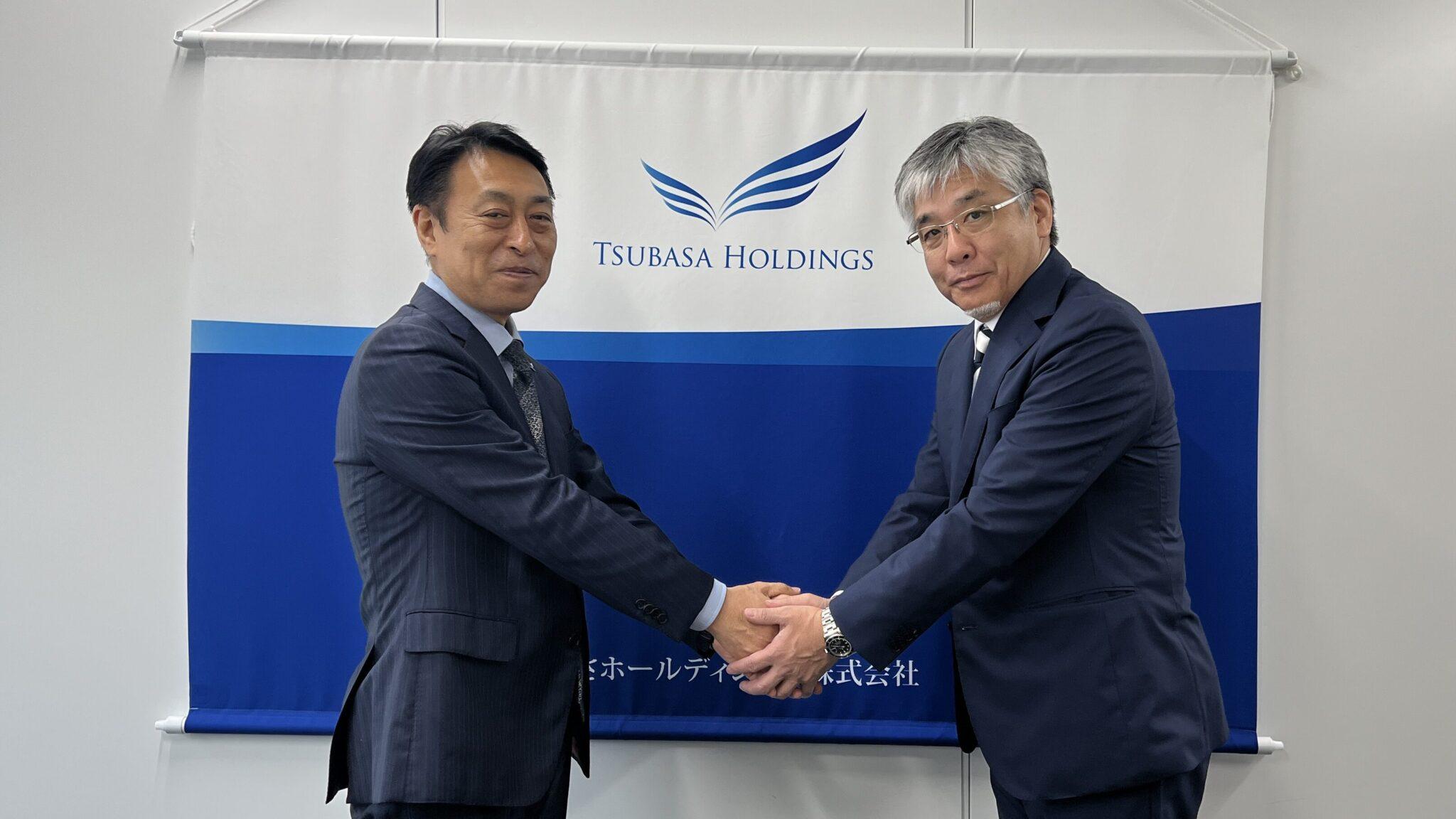 握手を交わすつばさHDの猪股社長㊧とベストワントランスポートの山川社長