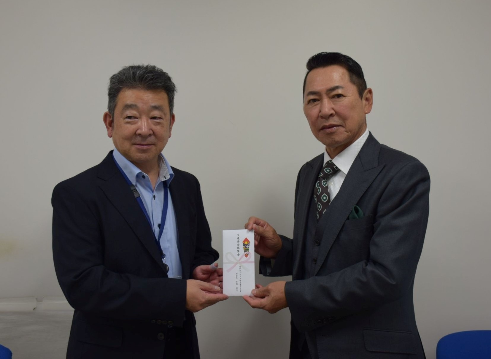 豊田みよし安協の佐藤英和事務局長㊧に目録を手渡す加納部会長