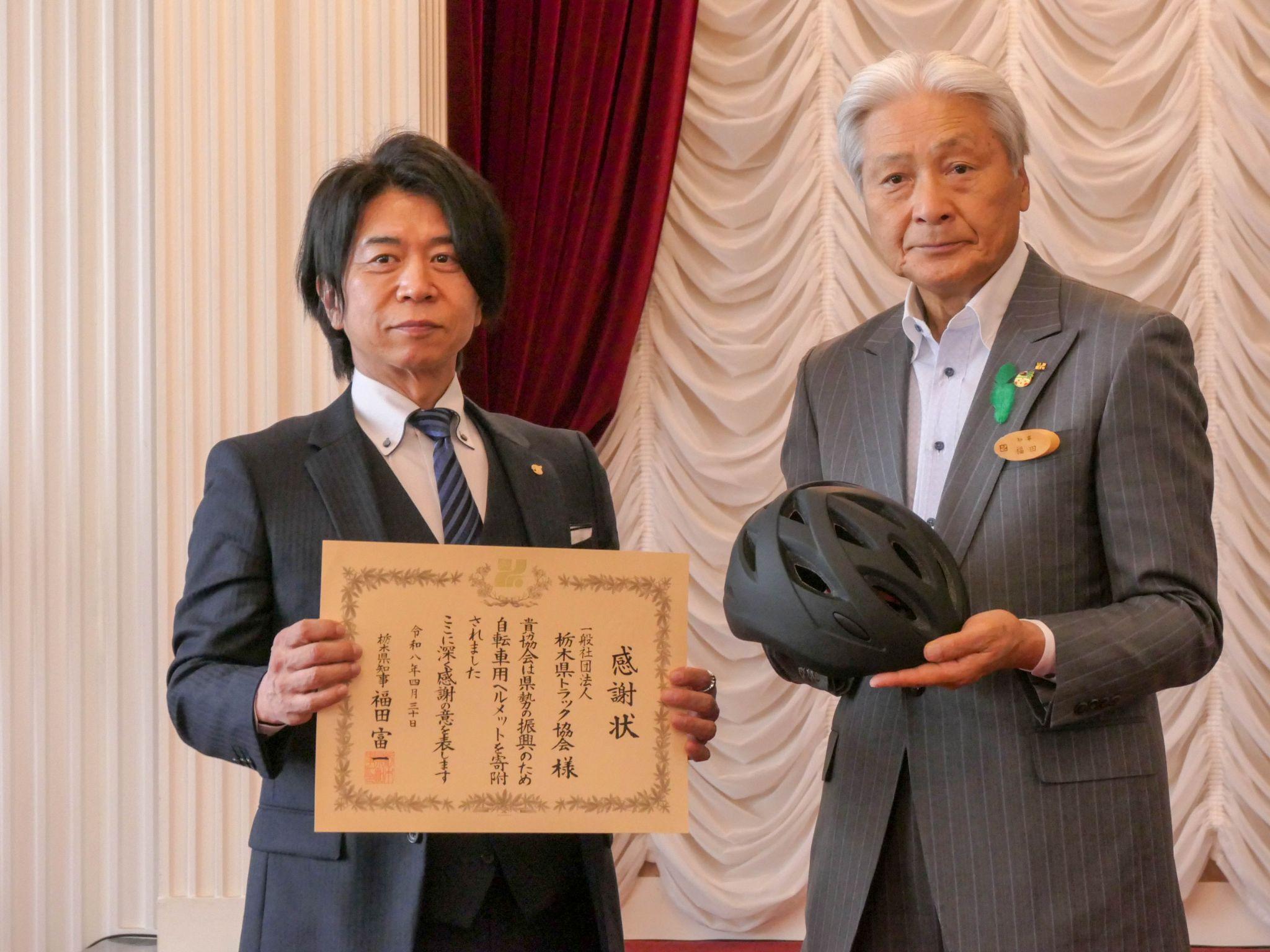 ヘルメットを持つ福田知事㊨と感謝状を持つ半田会長