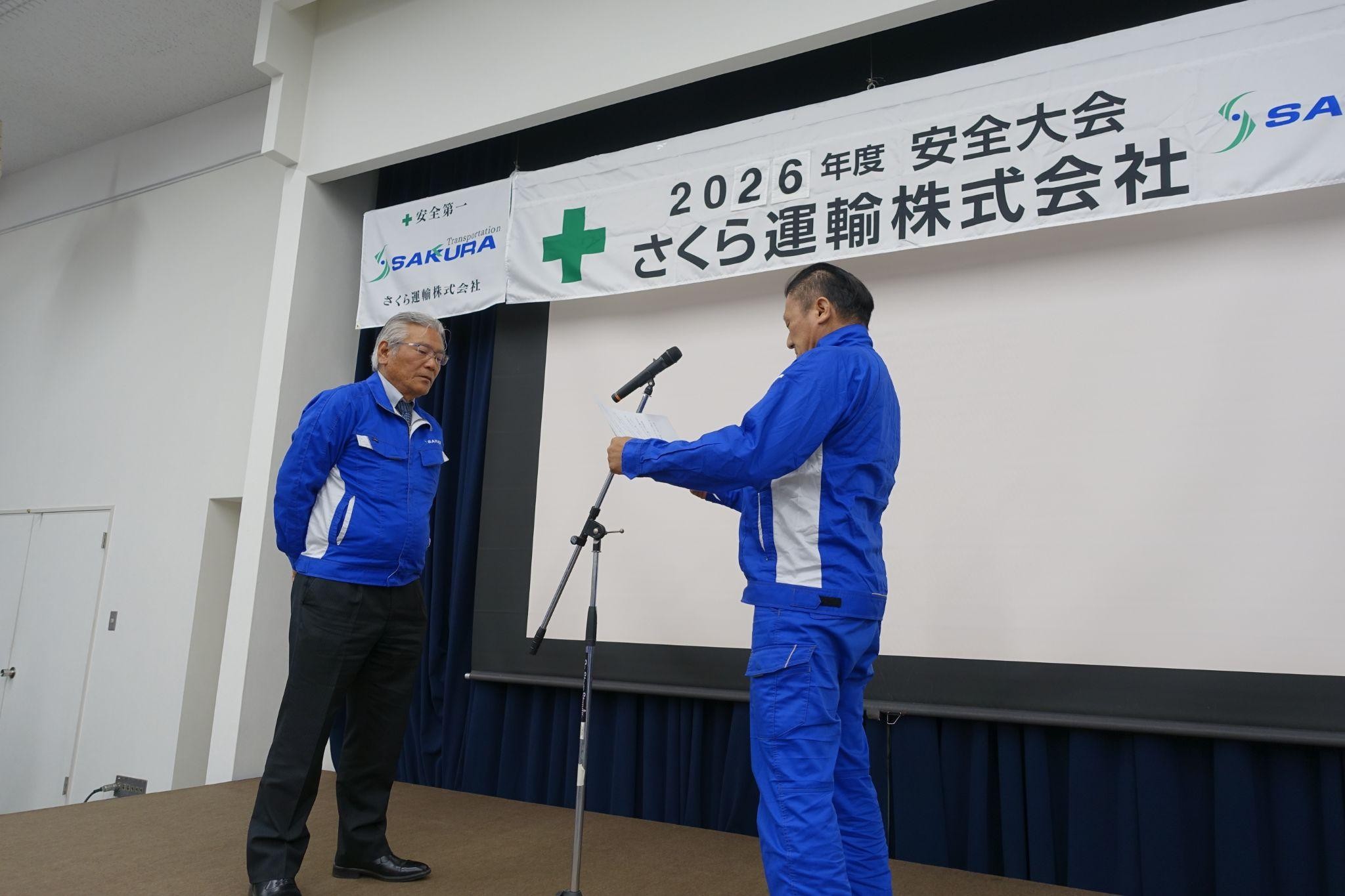 後藤社長㊧の前で安全決意表明を読み上げるドライバーの植木氏