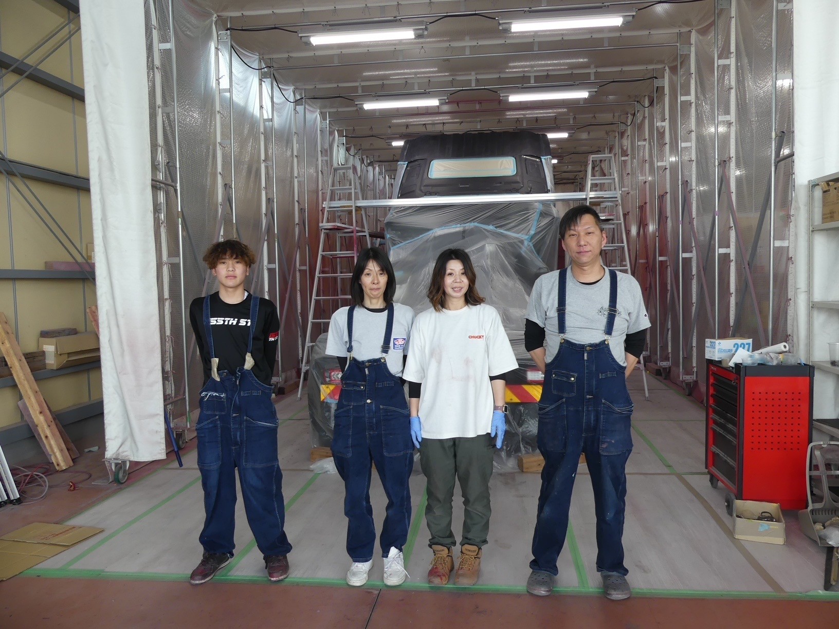 塗装作業中のトラクタをバックに社員