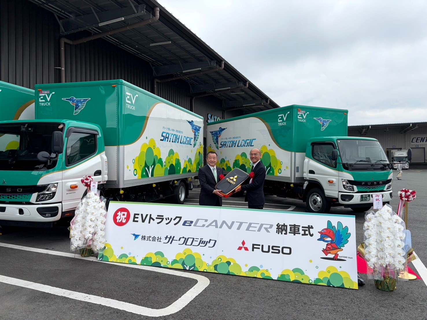 電気トラックを背に佐藤社長㊧と九州ふそうの近藤社長（8日）