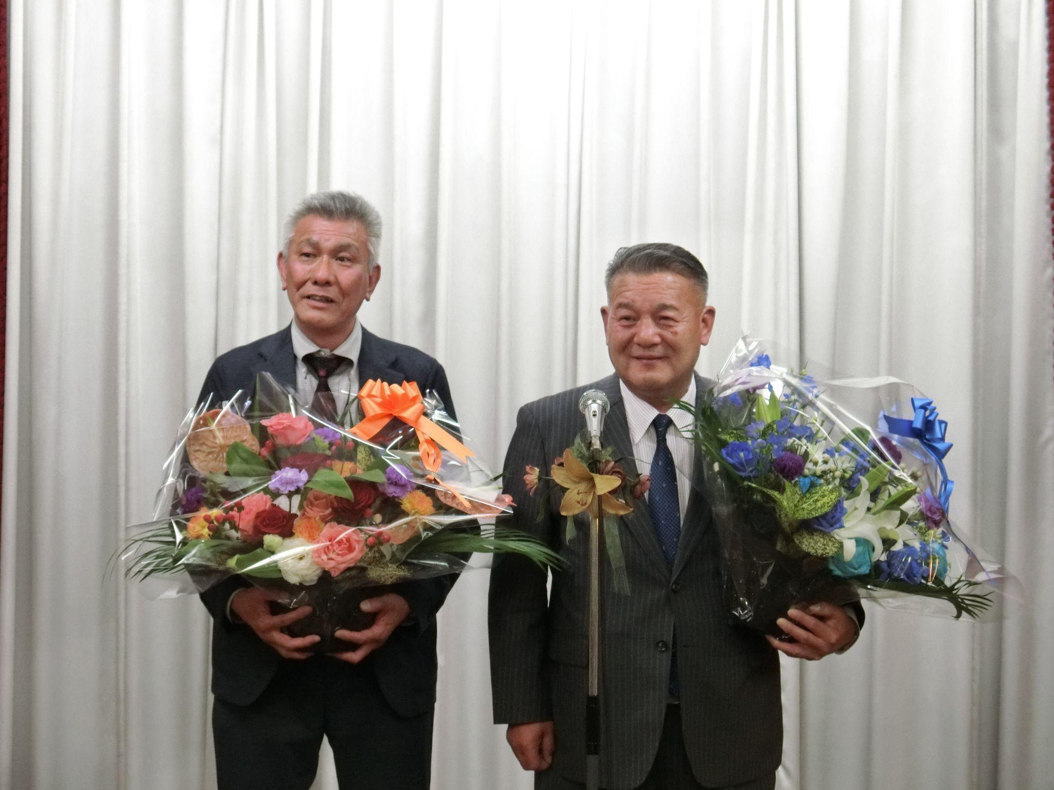 花束を受け取った朝比奈新支部長㊧と今成支部長