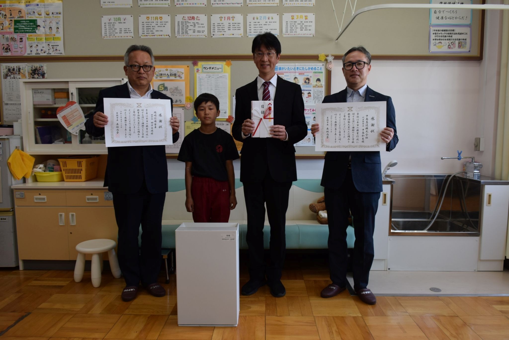 （右から）中島社長、大崎小の冨安校長、小学6年の坂上さん、岡崎信金の一木俊夫支店長