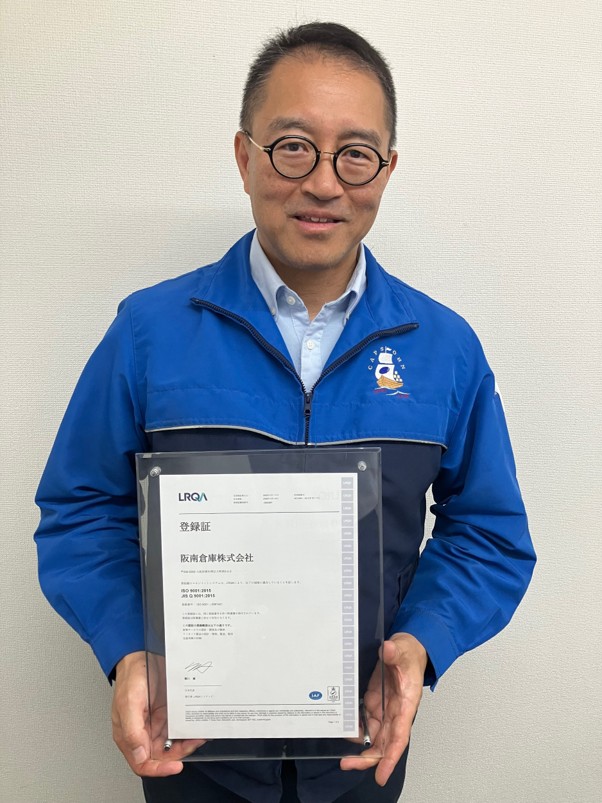 ISO9001の登録証を手にする堀畑社長